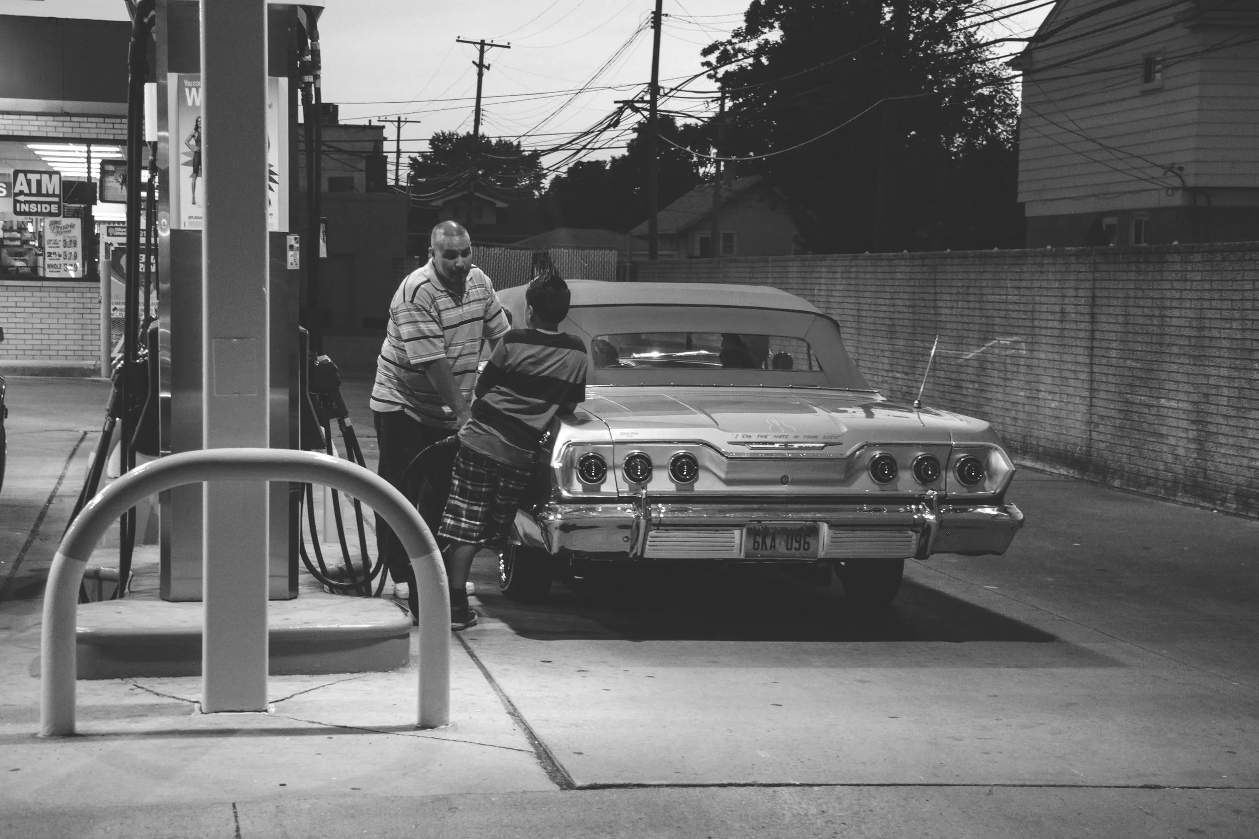 Checo of GoodTimes Car Club’s Detroit chapter fills up his 63 Impala with his son after Downriver Cruise, before heading back to the neighborhood. Southgate, MI. (2013)