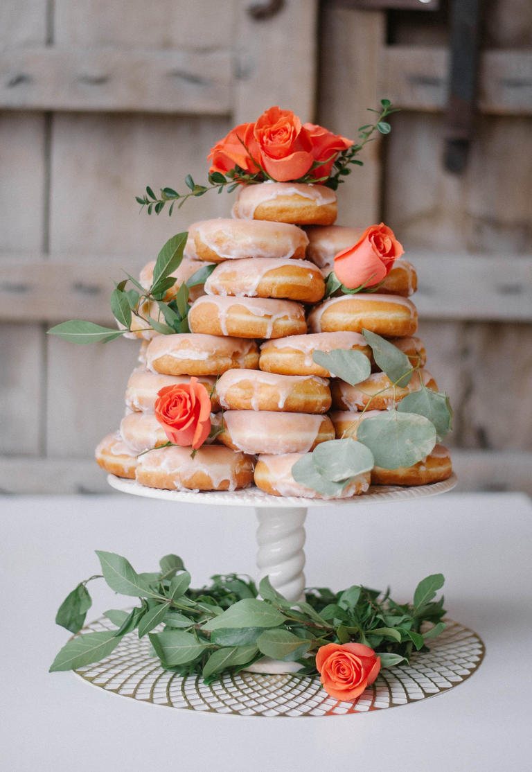 Orange roses and eucalyptus give this donut cake the perfect pop of color