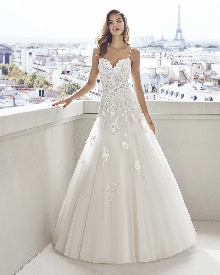 Lace and tulle princess-style wedding dress. Semi-sweetheart neckline, beaded straps and skirt and bodice with lace appliqués. Luna Novias Vesna