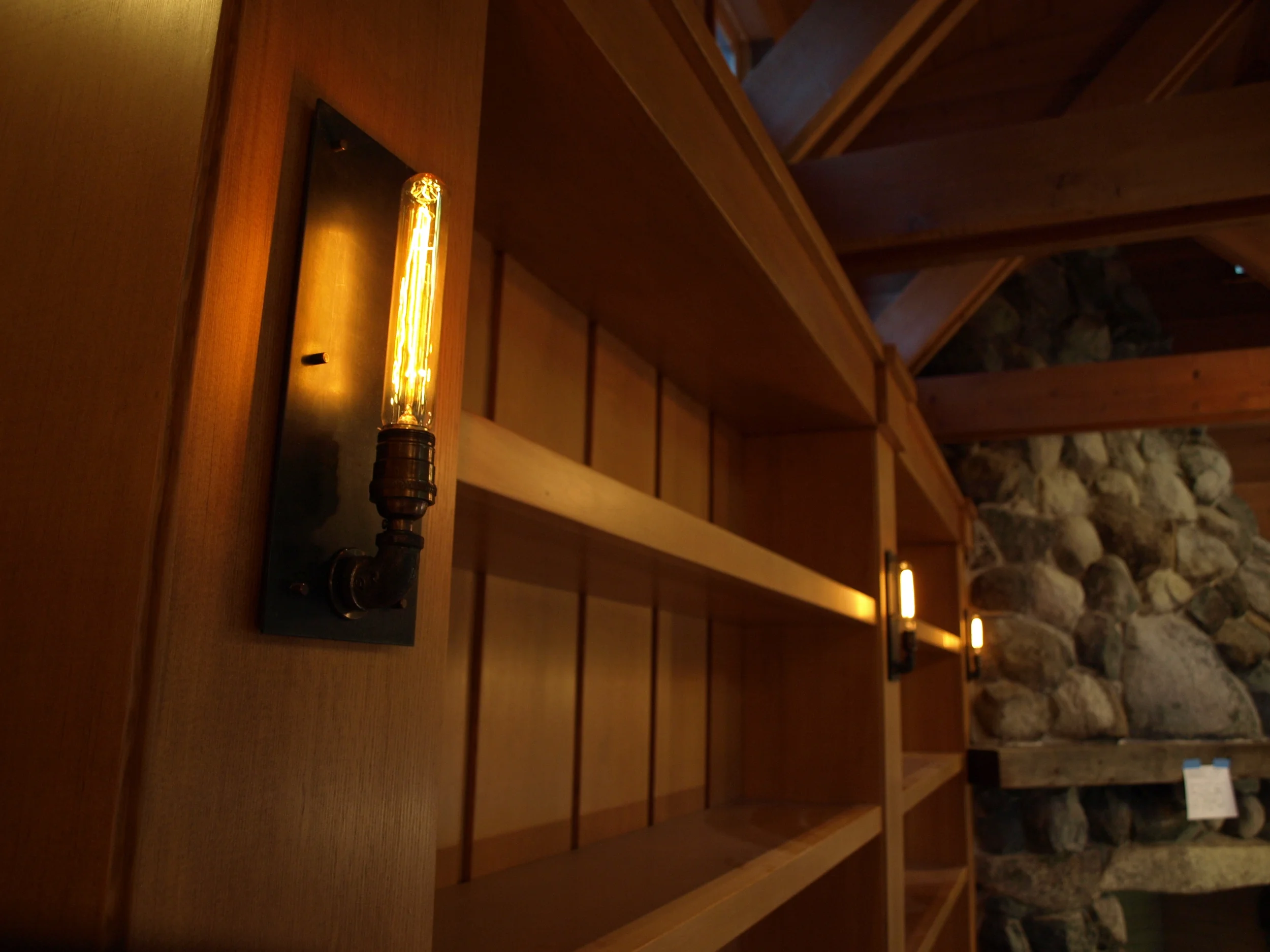 Bookcase sconces in blackened steel/ Mark Becker Architects