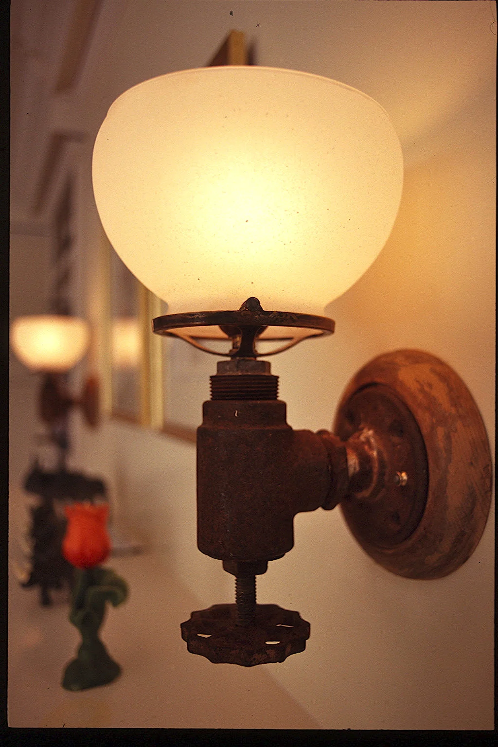 Rusty valve sconces over a fireplace mantle