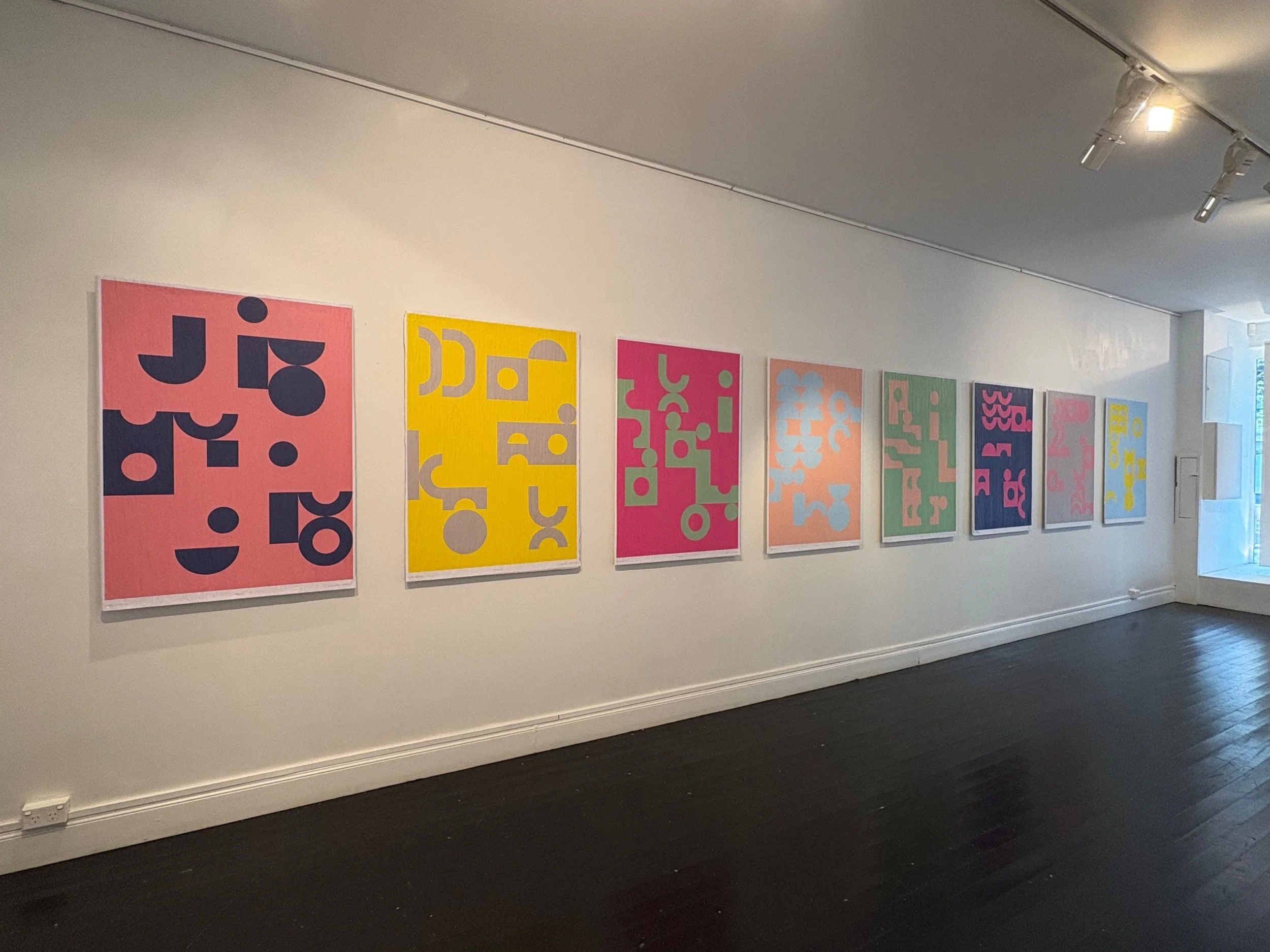 Mark Gowing exhibition in Sydney, a row of large colourful geometric poster prints on a gallery wall