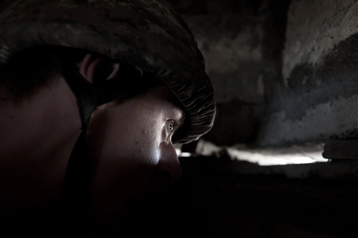 Arman, a young conscript from Voskevaz village, watches the Azerbaijani frontline located 30 meters from his lookout post on the Mataghis frontline, Nagorno-Karbakh. 