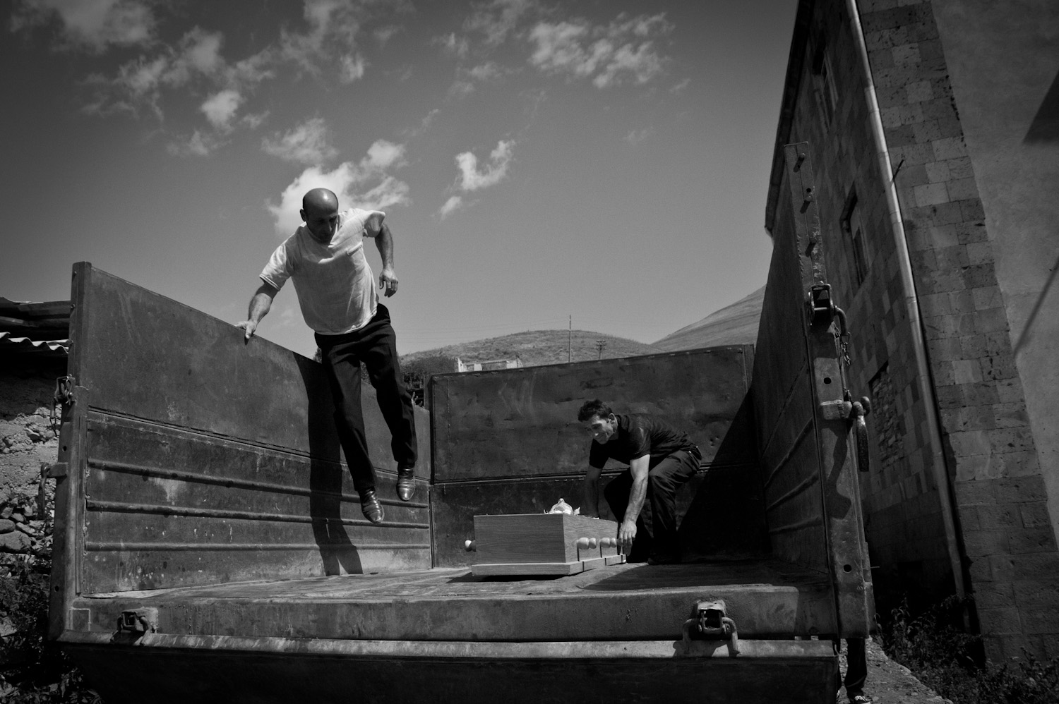  Zakhar, the town veterinarian, jumps into a jump truck which doubles as a hearse at funerals in Dastakert. 70% of the town's residents are refugees from the cities of Baku, Sumgait, or Kirovabad.   