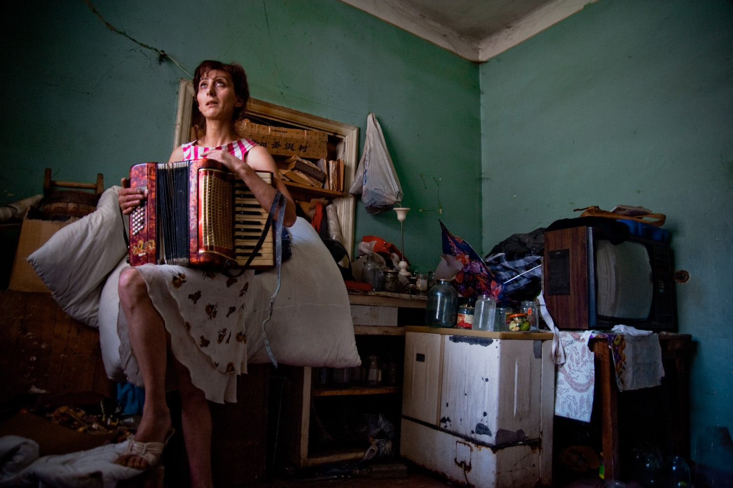  Narine with the accordion she once played as a girl. With her 4 children, she escaped an abusive, alcoholic husband who regularly beat and raped her. The family now lives in this dilapidated house in Arinch village.  