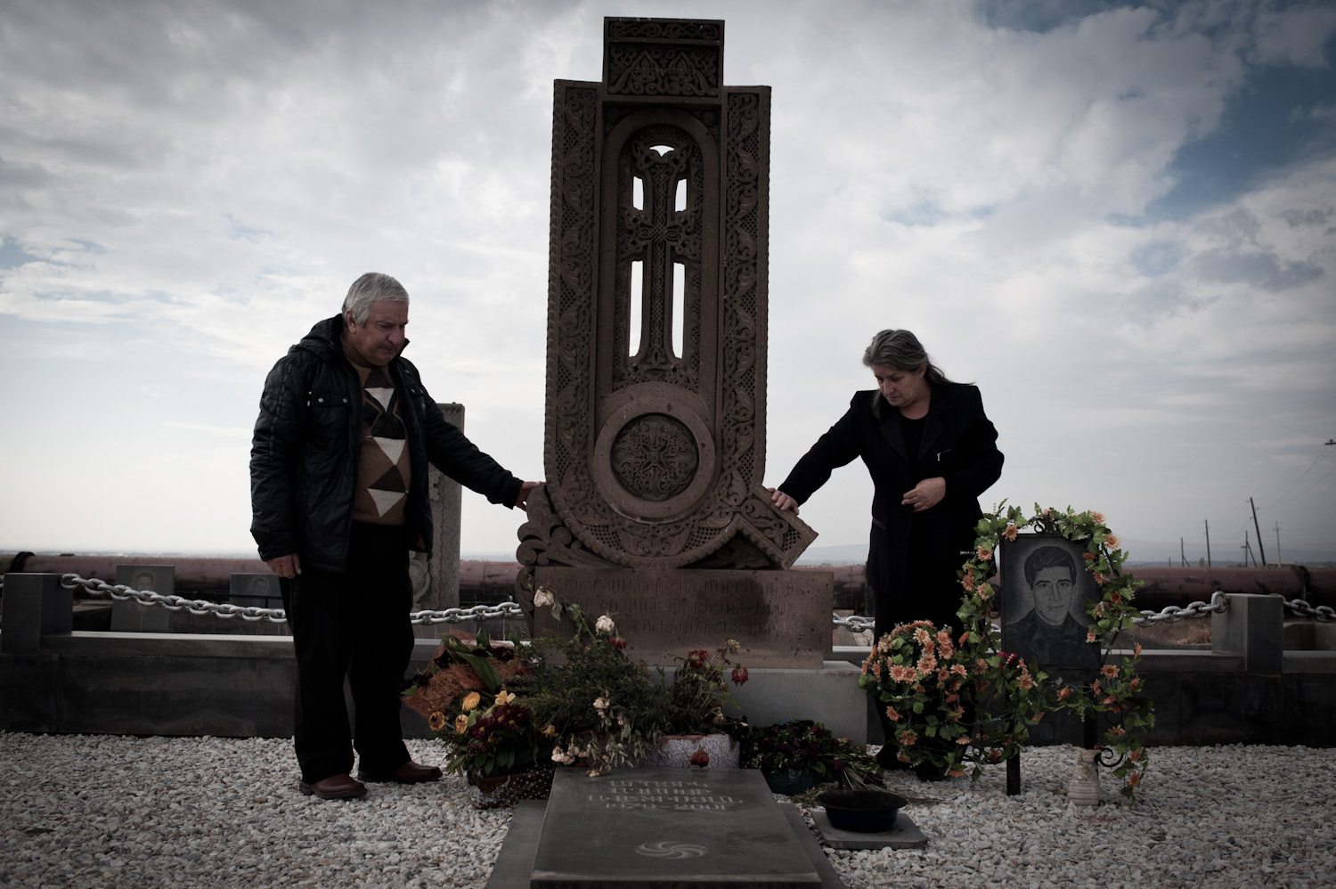 Anahit and Aghasi at their son's grave. "While serving, my son would describe how the battalion commander would grab soldiers by the collar and put his loaded gun to their heads to scare them. This is the same way my son was killed."
