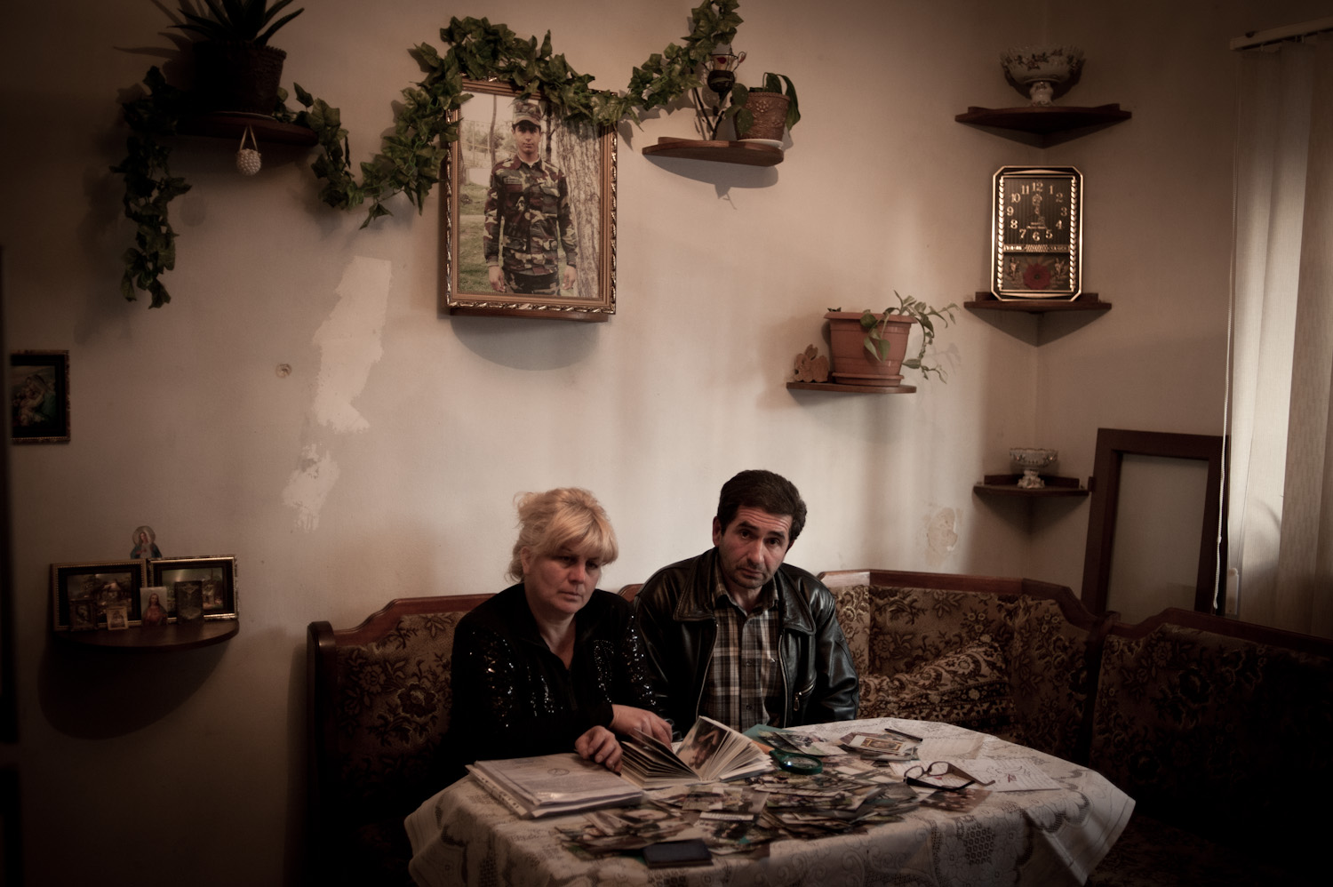  Arthur's parents Smbat and Irina sit beneath their son's portrait sifting through case files, paperwork and autopsy photographs related to their son's death.   