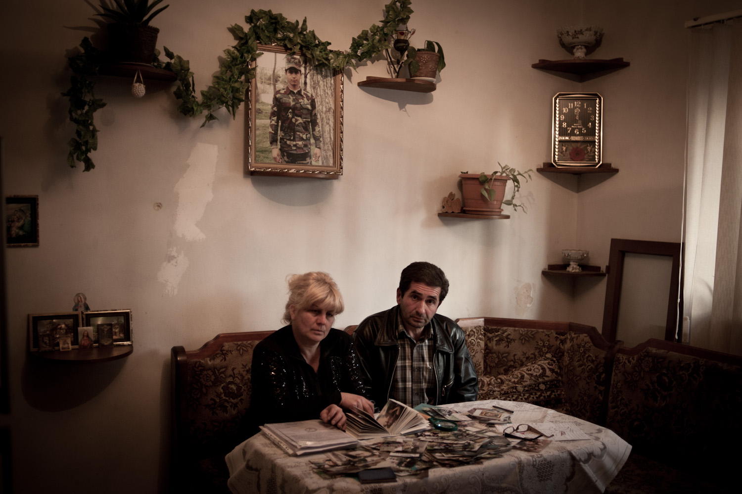 Arthur's parents Smbat and Irina sit beneath their son's portrait sifting through case files, paperwork and autopsy photographs related to their son's death.