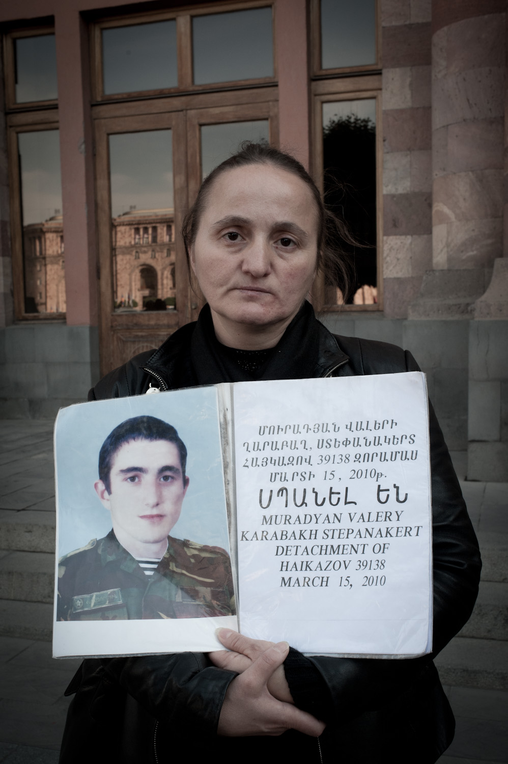 Cradling her deceased son Valery's photograph, Nana Muradyan stands in
front of the government building in Yerevan where she and other mothers
protest the unsolved crimes committed against their sons during their
mandatory military service.