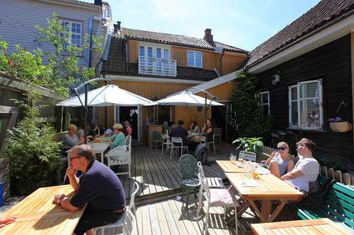 I sommerhalvåret kan du nyte de sjarmerende bakgårdene i Gamlebyen. Hos Mormors Café er det sitteplasser både i bakgården og på fortauet utenfor. Foto: © Eirik Dahl/Visit Hvaler