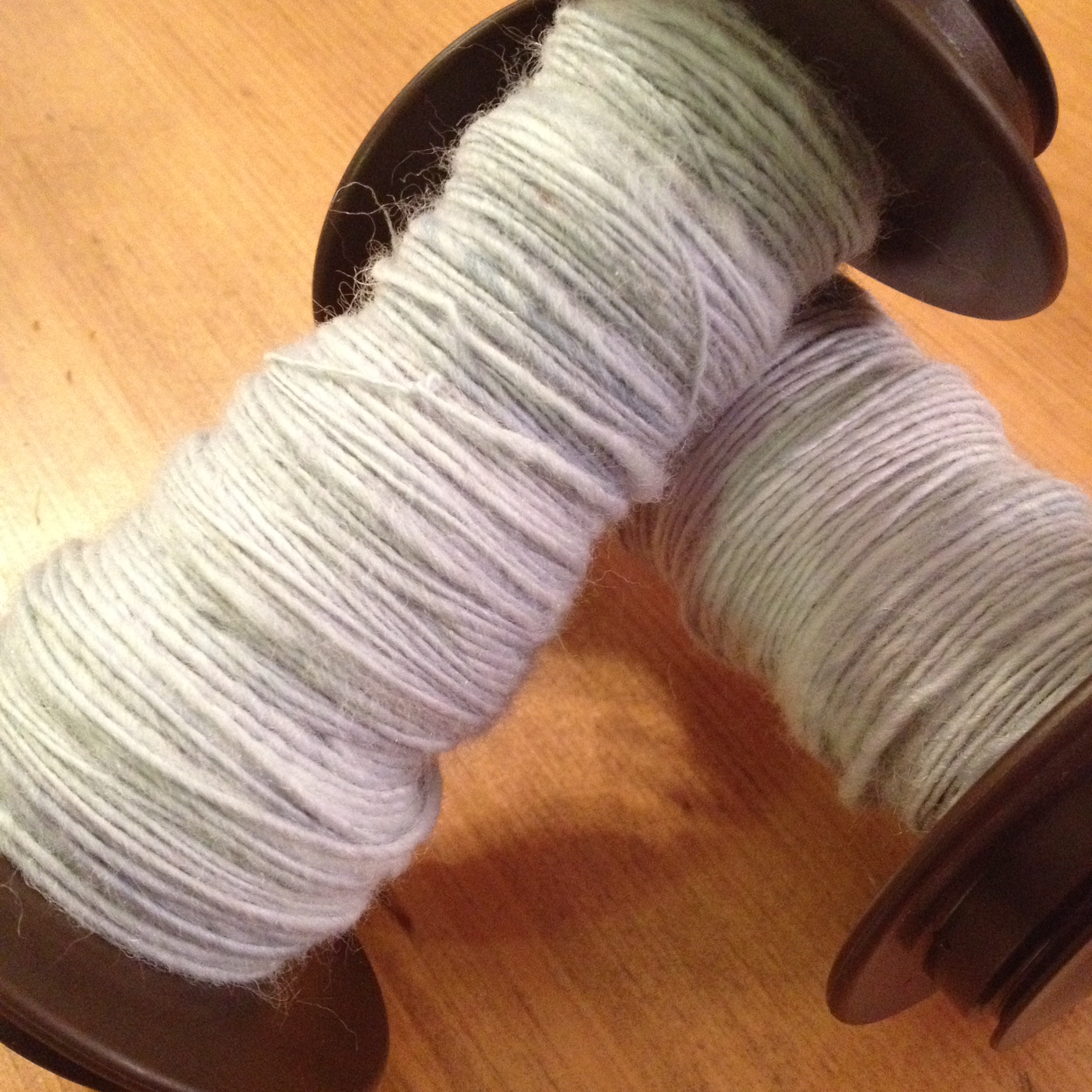 Two bobbins, on the left true woolen and on the right semi-woolen from combed top