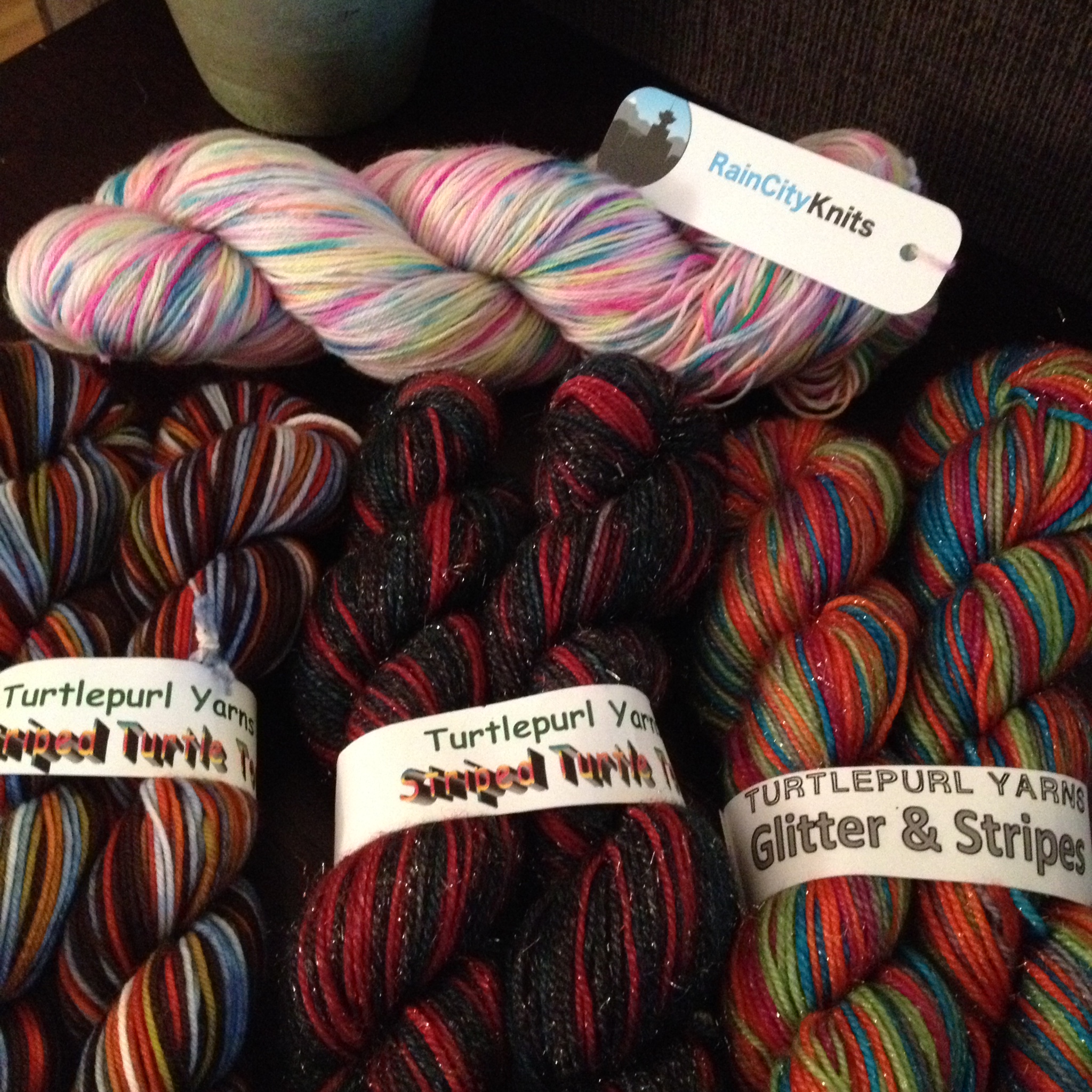 This year's Frolic yarn goodies. Up top, Merino/Nylon sock yarn from Rain City Knits in Graffiti (I'm thinking a pair of Hermione's Everyday Socks by Erica Lueder) and then three skeins of Turtlepurl Yarns for some stripe-y vanilla socks. The skein in the middle (sparkly red and black) is for my mom.