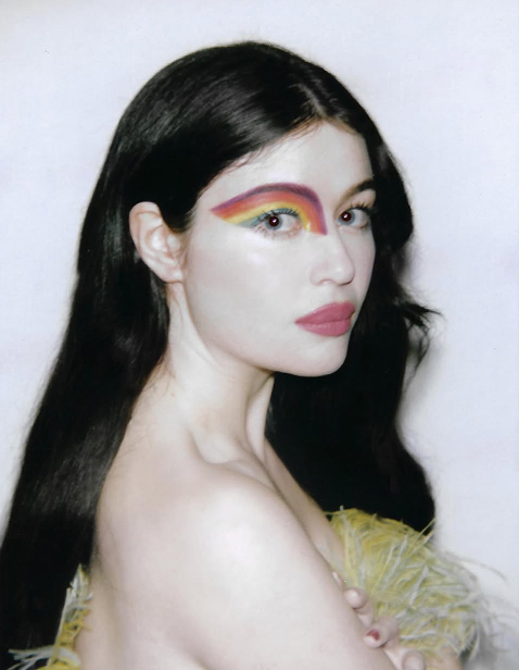 Image of artist with a rainbow paint on their face.