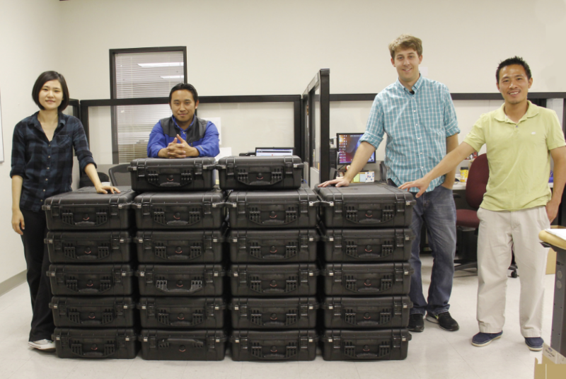 Members of the Crystal Instruments production team pose with a stack of CoCo-80 handheld vibration monitoring devices ready for shipment in June 2015