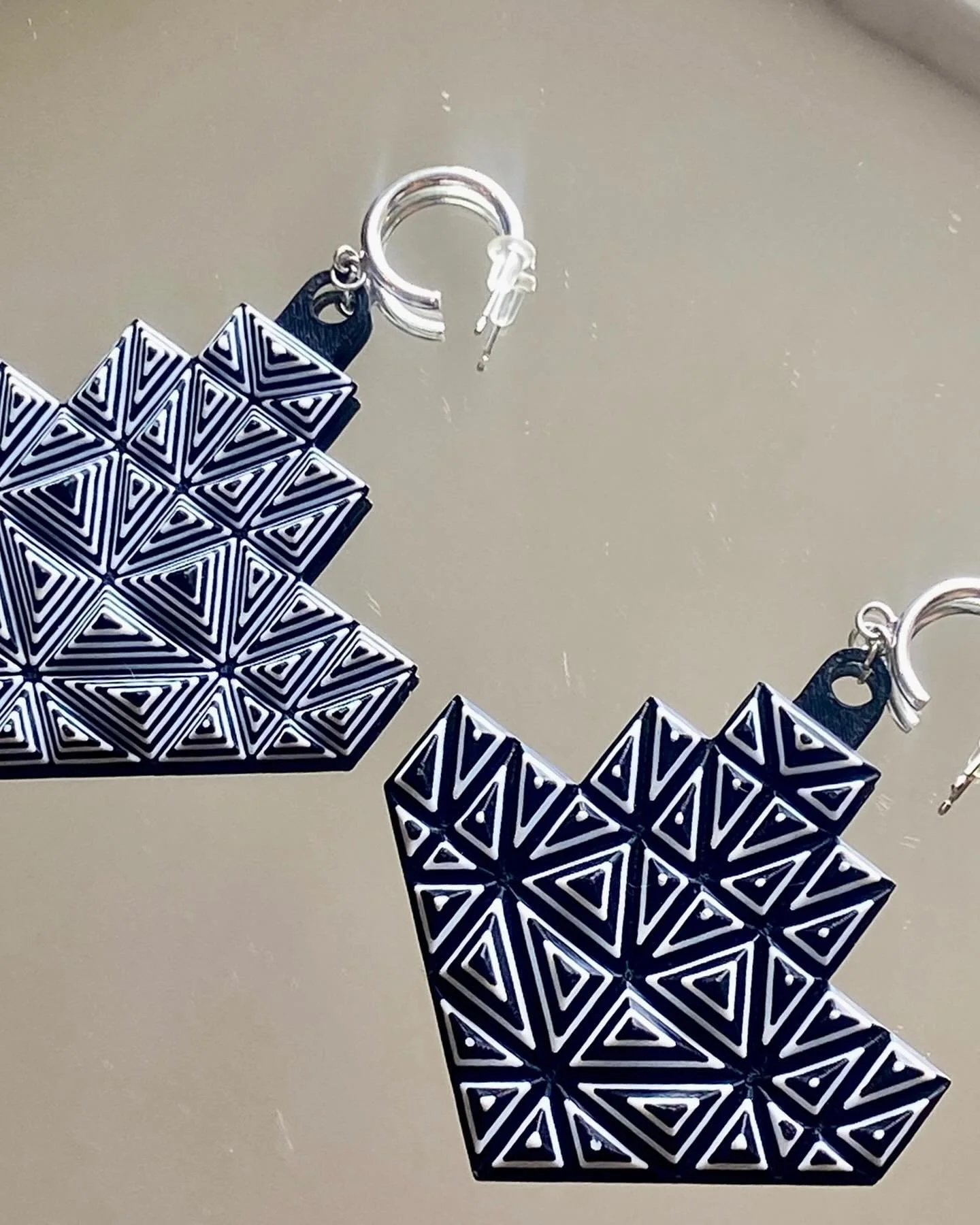 These big asymmetrical monochromatic earrings are now available in store.  Only one pair is available with this unique 3d printed bio polymer design, and rhodium plated mini hoop earring. Presents for yourself love or someone else, we got you with Ac