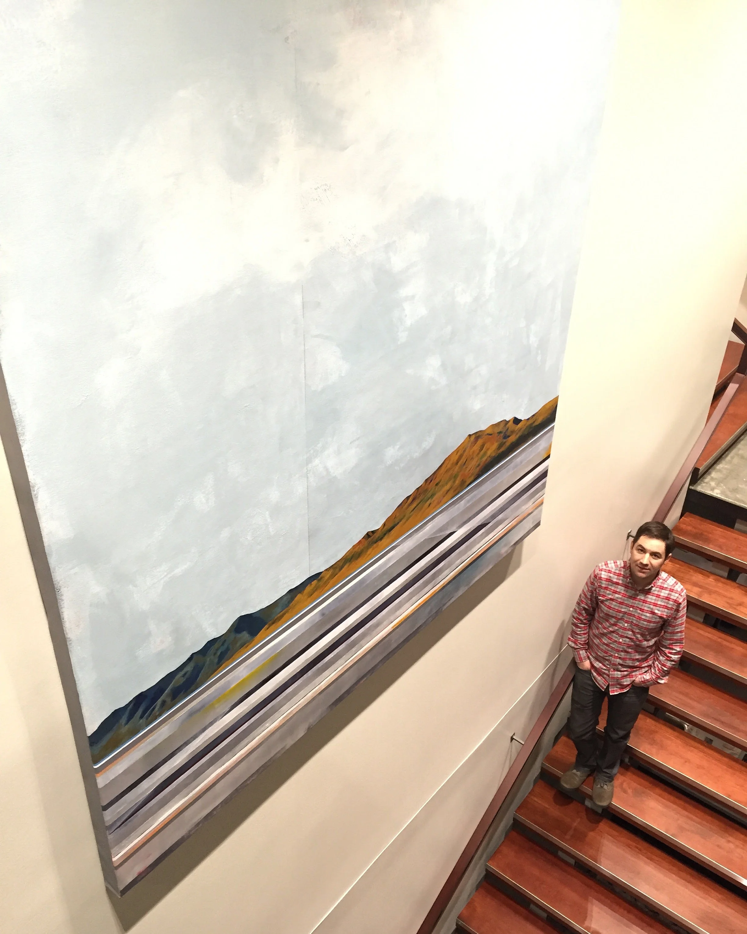 Justin stands next to the painting, which will be on permanent display at the library.
