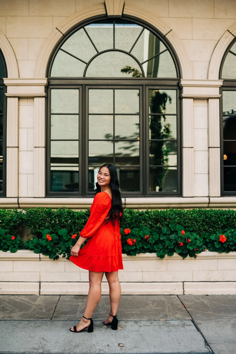 senior in red dress near black window.jpg