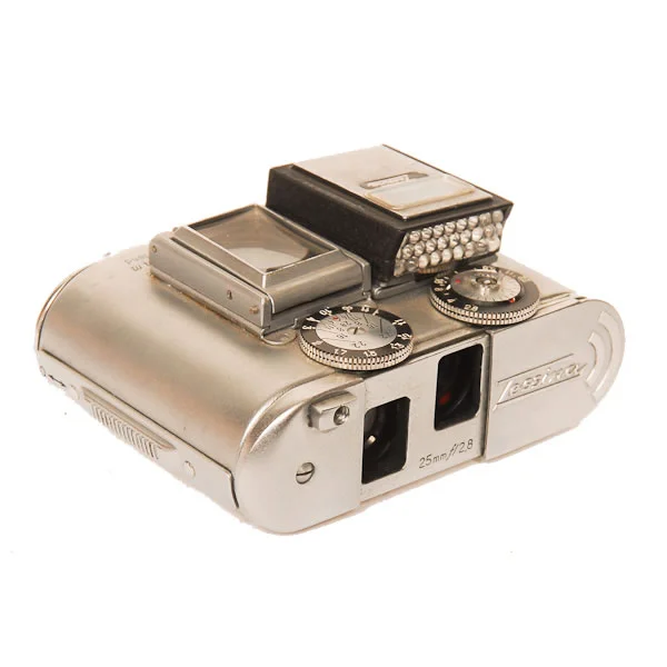 Concava Tessina 1957-1996 This 35mm film (loaded in special cartridges) camera came with a watch band so that it could be worn like a watch. It is a twin lens reflex camera with one lens reflecting up to the viewer and one lens reflecting down to the film. It had a range of shutter speeds from 1/2 to 1/500 of a second. A spring driven motor could advance the film up to 8 frames per winding. The view finder (square glass) would tilt up for aiming. All of this in a device the 1/2 size of a pack of cigarettes.