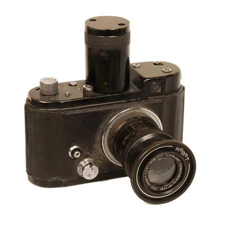 Robot Luftwaffen 1940-1945 Used for aerial photography by the German Luftwaffen in WWII. A half frame camera on 35mm film. This model has a 75mm F/3.8 Schneider lens. Note the oversized spring winder designed for use by pilots with heavy flight gloves on.