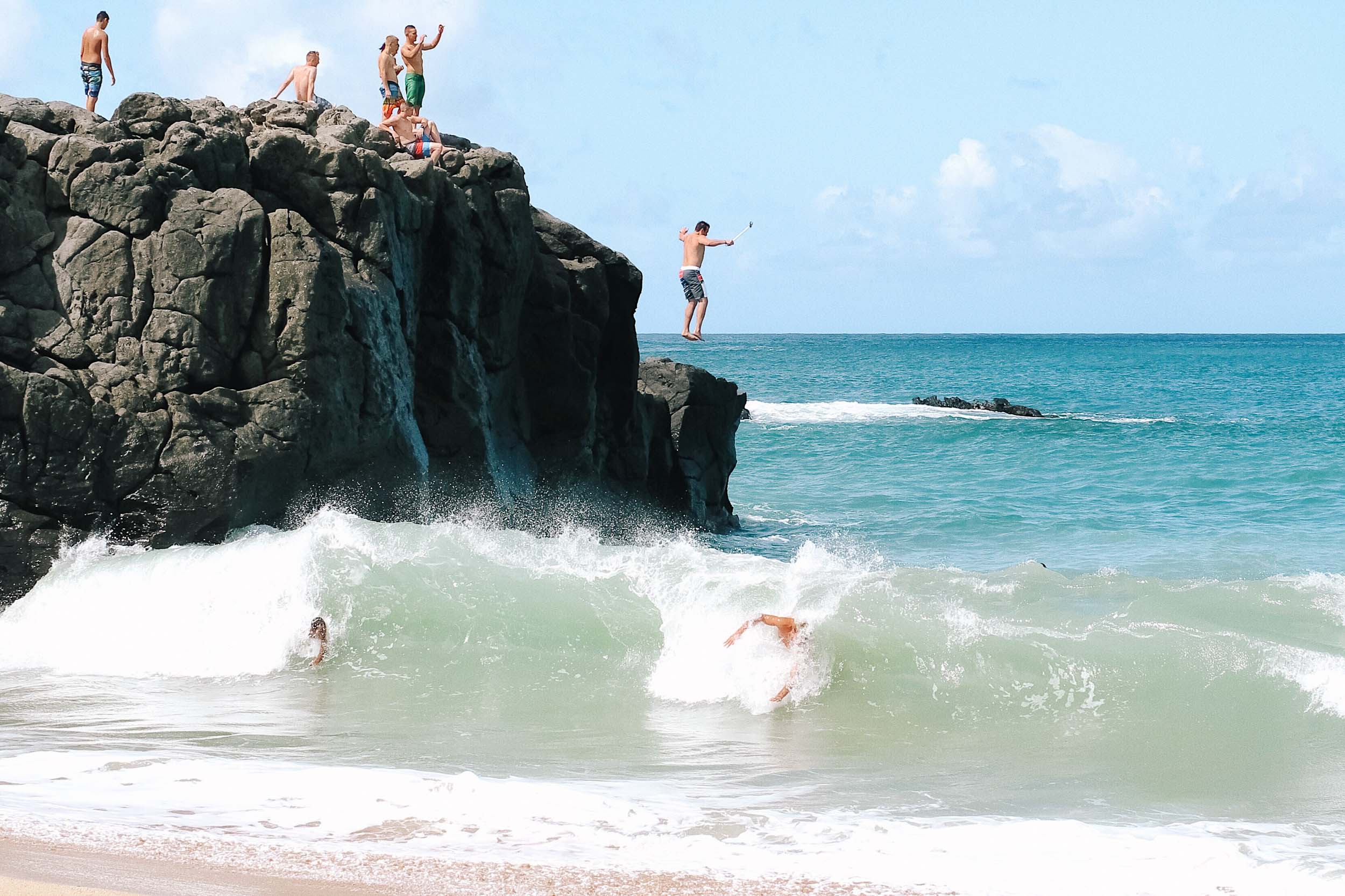 Jumping off a rock at Waimea Bay