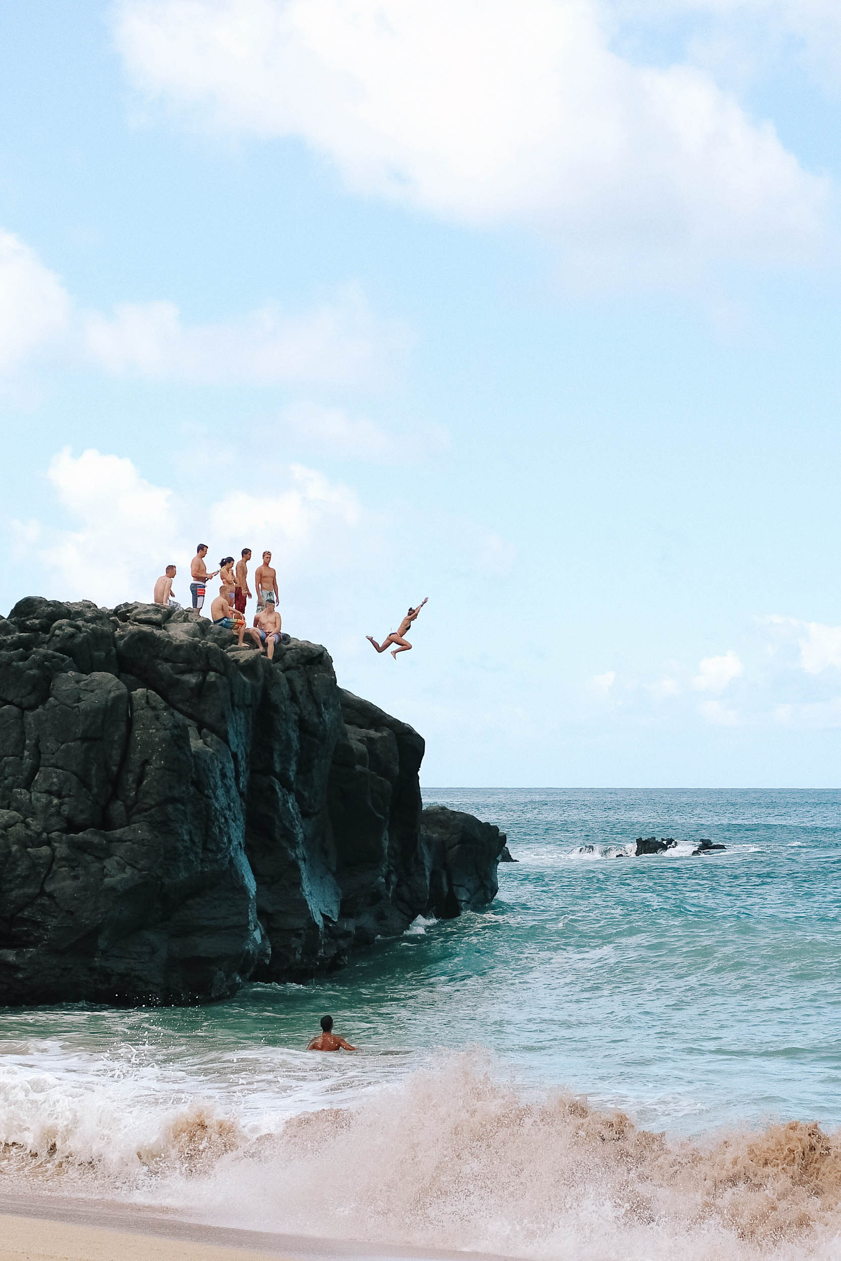 Jumping off a rock at Waimea Bay