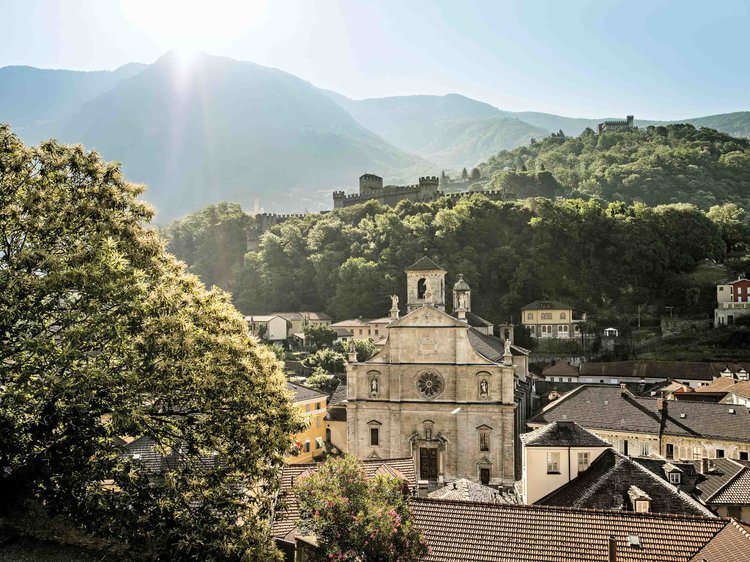 View of Collegiate Church of SS. Pietro and Stefano with castle Montebello and Sasso Corbaro in the background, Bellinzona.