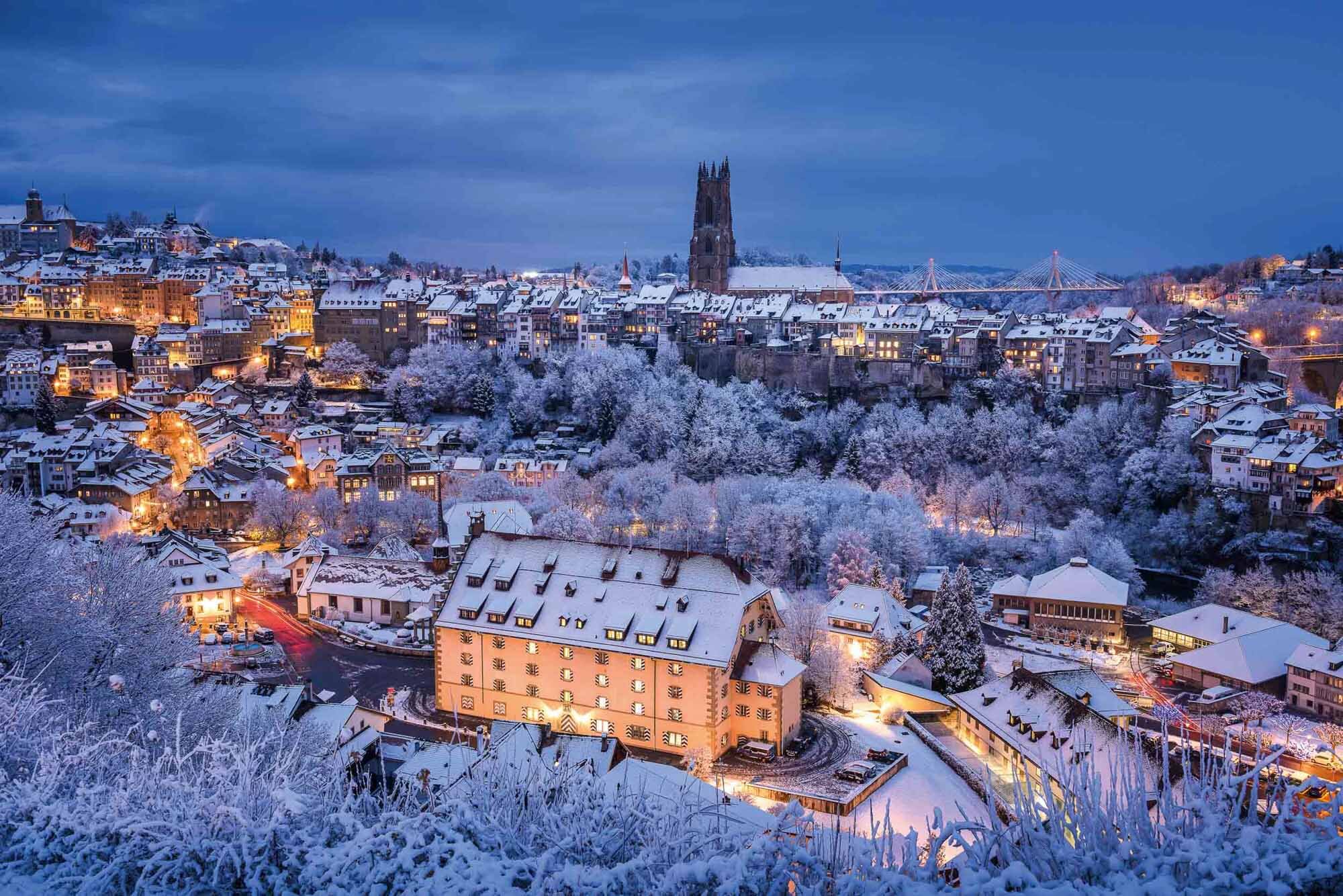 Daybreak with winter panorama in Friborg with the cathedral and the Poyabruecke in the background. Copyright by: Switzerland Tourism