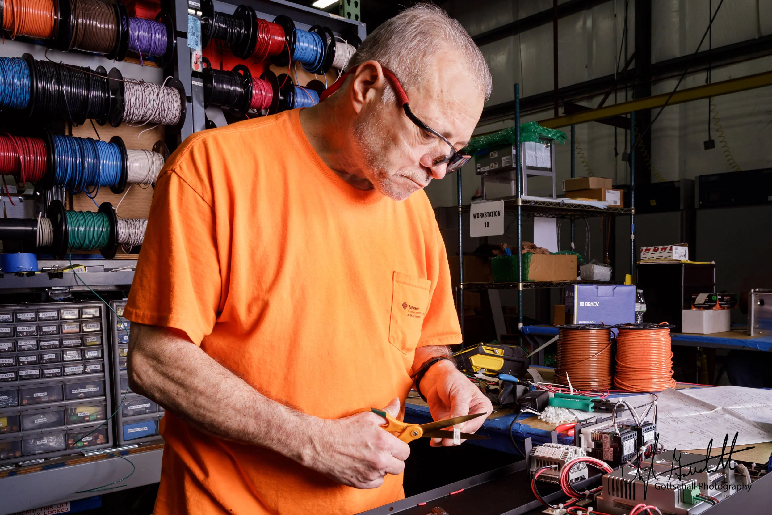 An assembly worker, on the manufacturing floor, wires and labels components that will be installed in an enclosureI enjoy seeing and learning what the people behind the scenes do and how it all comes together.