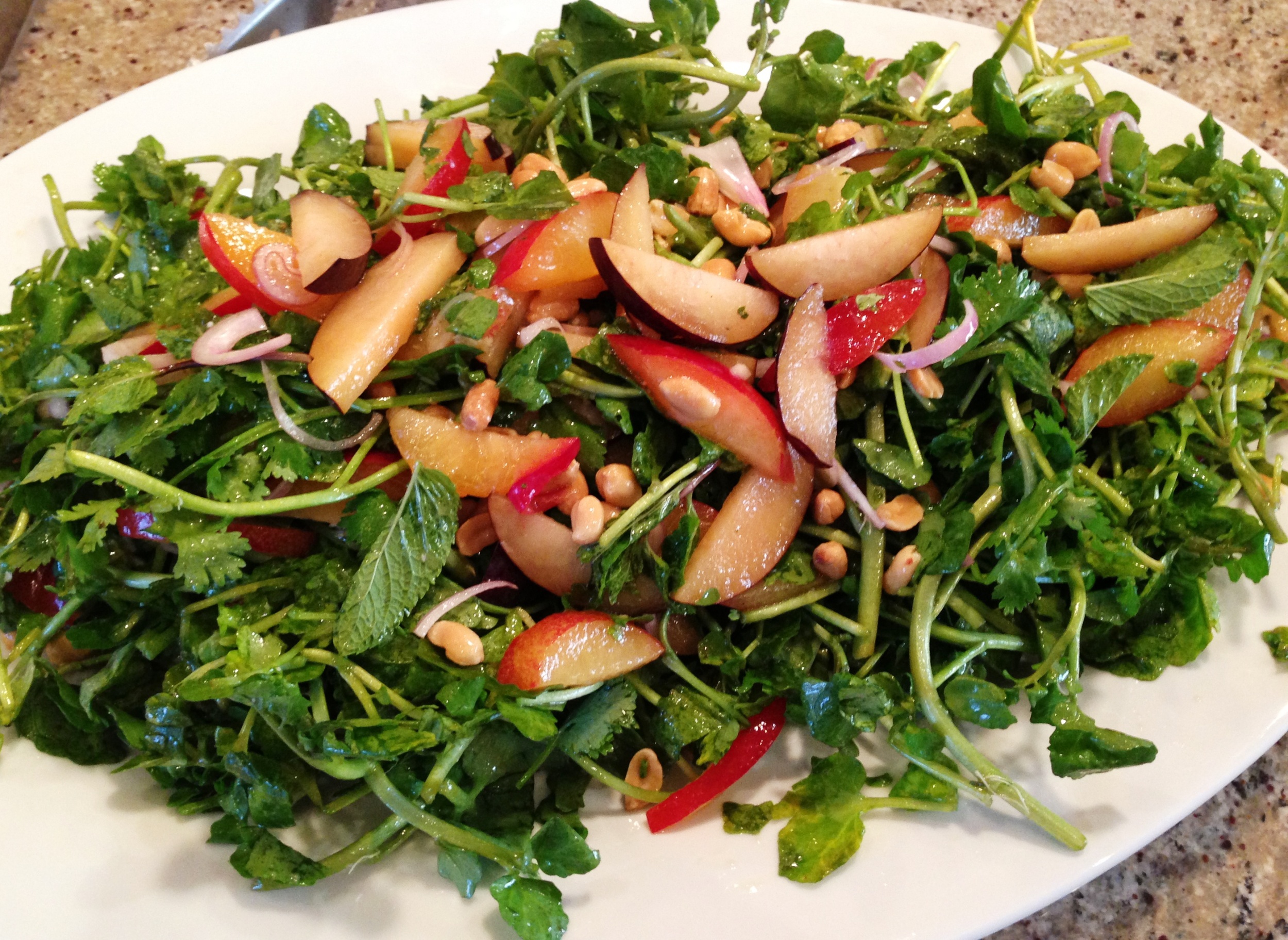 Watercress and herb salad with stone fruit, red onion, peanuts, and Vietnamese nuoc mam vinaigrette