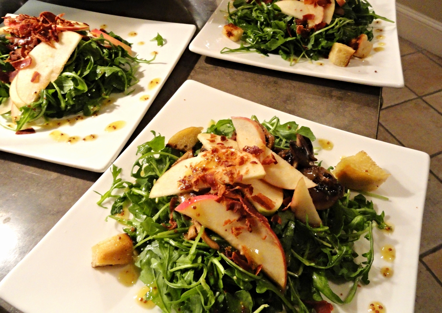 Arugula salad with apples, pecans, crumbled bacon, croutons, and whole grain mustard vinaigrette