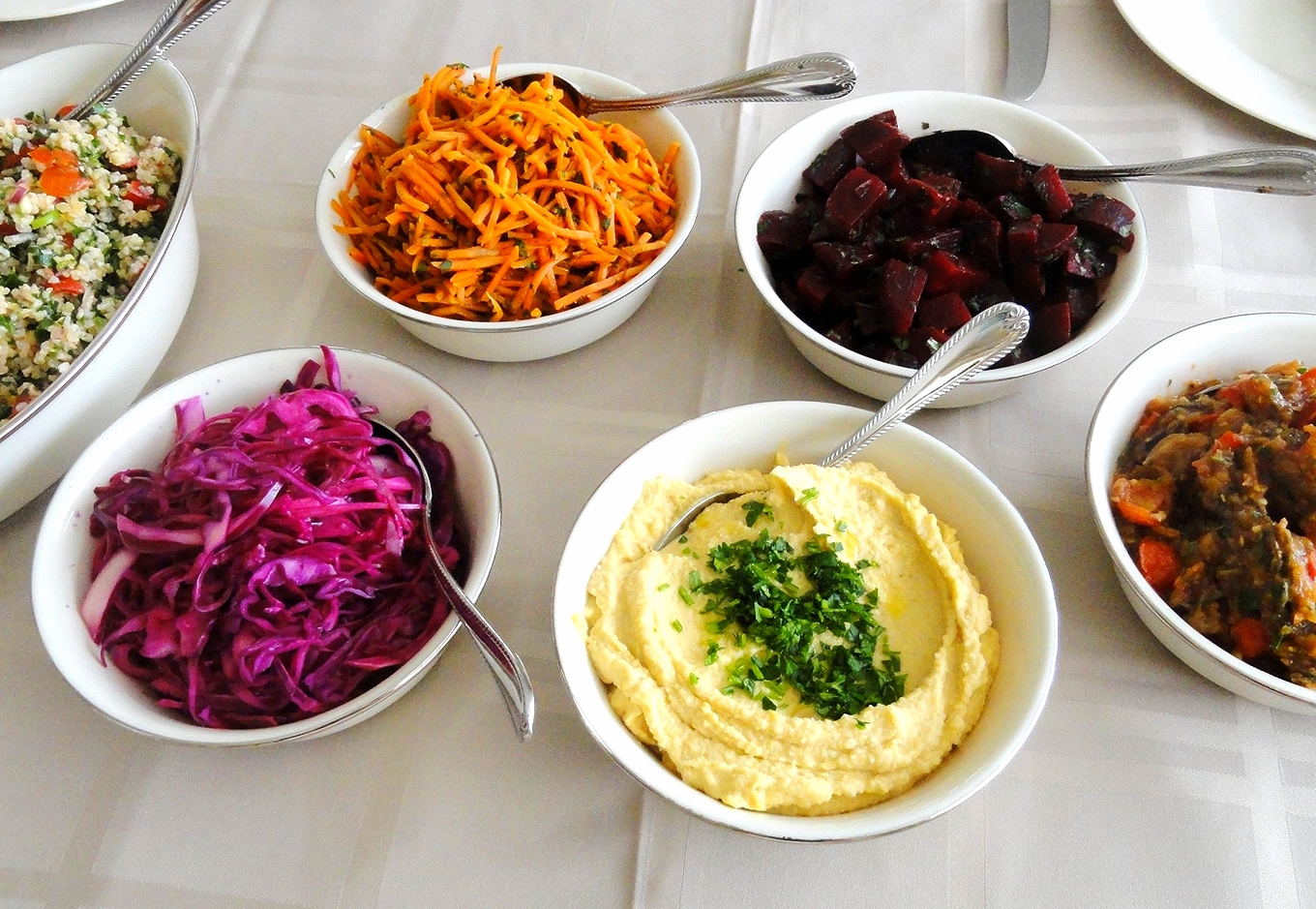 Israeli salads: vegetable Israeli couscous, red cabbage, carrot-cumin, hummus, Moroccan spiced beets, roasted eggplant and tomato with za'atar