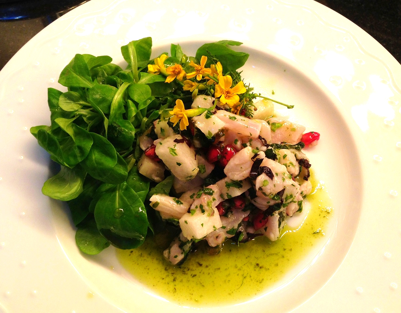 Sea bass ceviche with herb oil, pomegranate, opal basil, and edible flowers