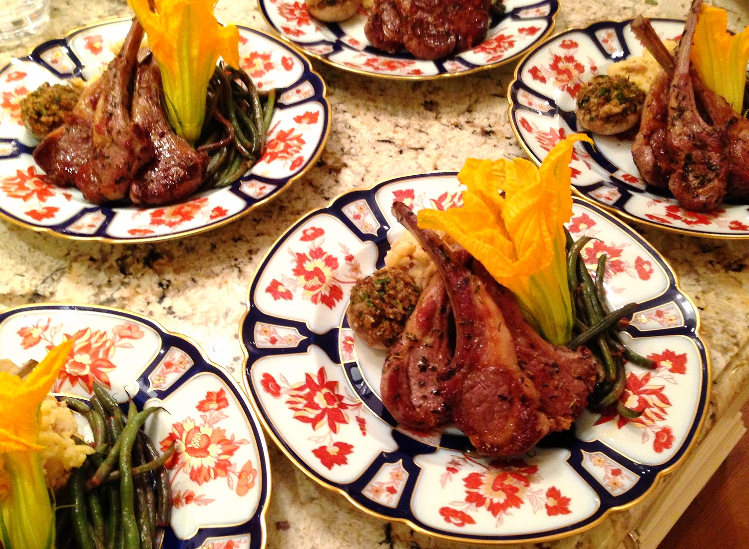 Lamb chops scottadito with herbs de Provence, stuffed mushrooms, French green beans, and zucchini flower