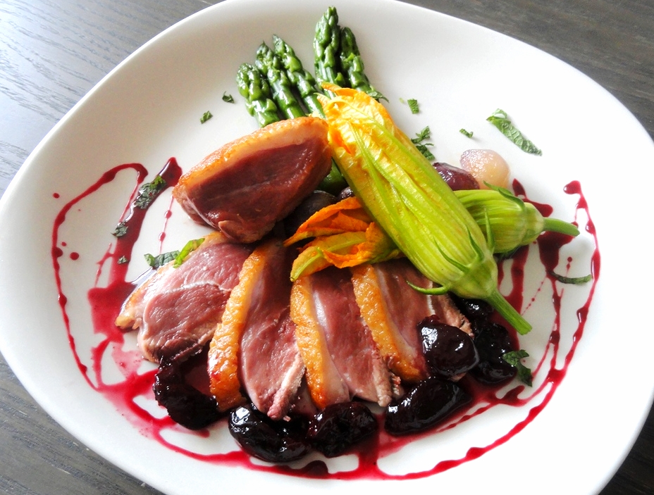 Pan-seared Long Island duck breast with asparagus, zucchini flowers, and a cherry-port reduction