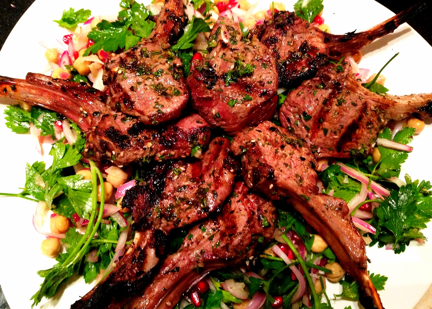 Moroccan spiced grilled lamb chops on parsley, chickpea, red onion, and pomegranate salad