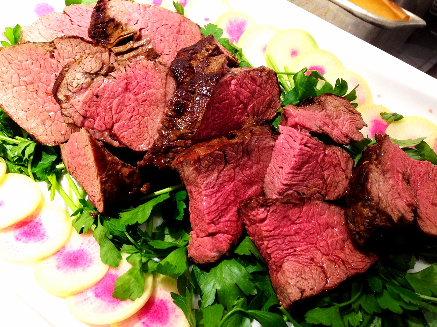 Seared herbed kosher for Passover beef tenderloin on parsley and watermelon radish salad
