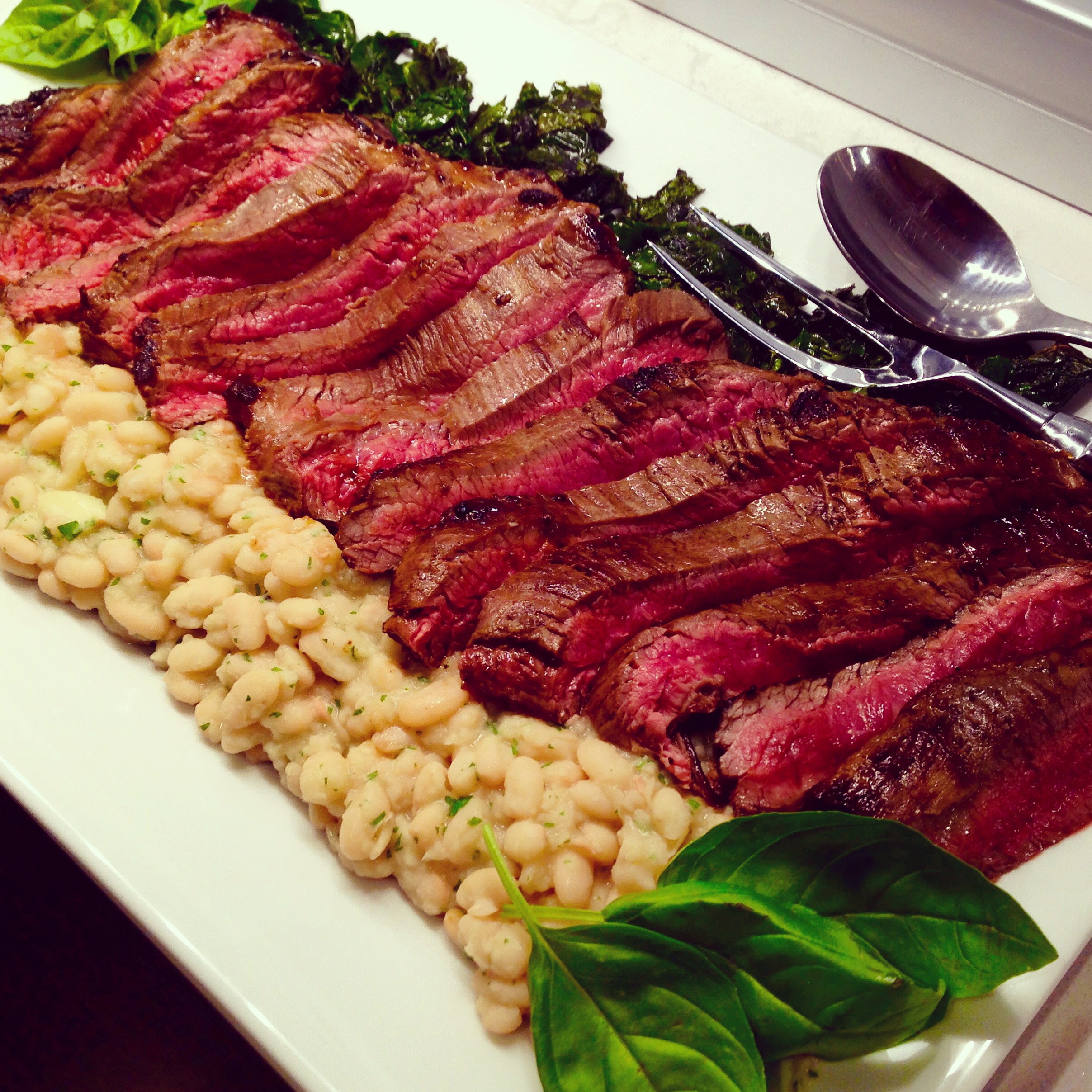 Sliced beef tagliata, Tuscan kale, and roasted garlic-rosemary cannellini beans