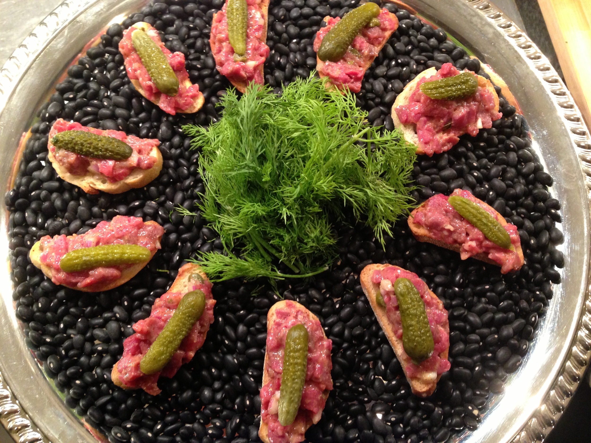 Hand-cut beef tartare on crostini with gherkins