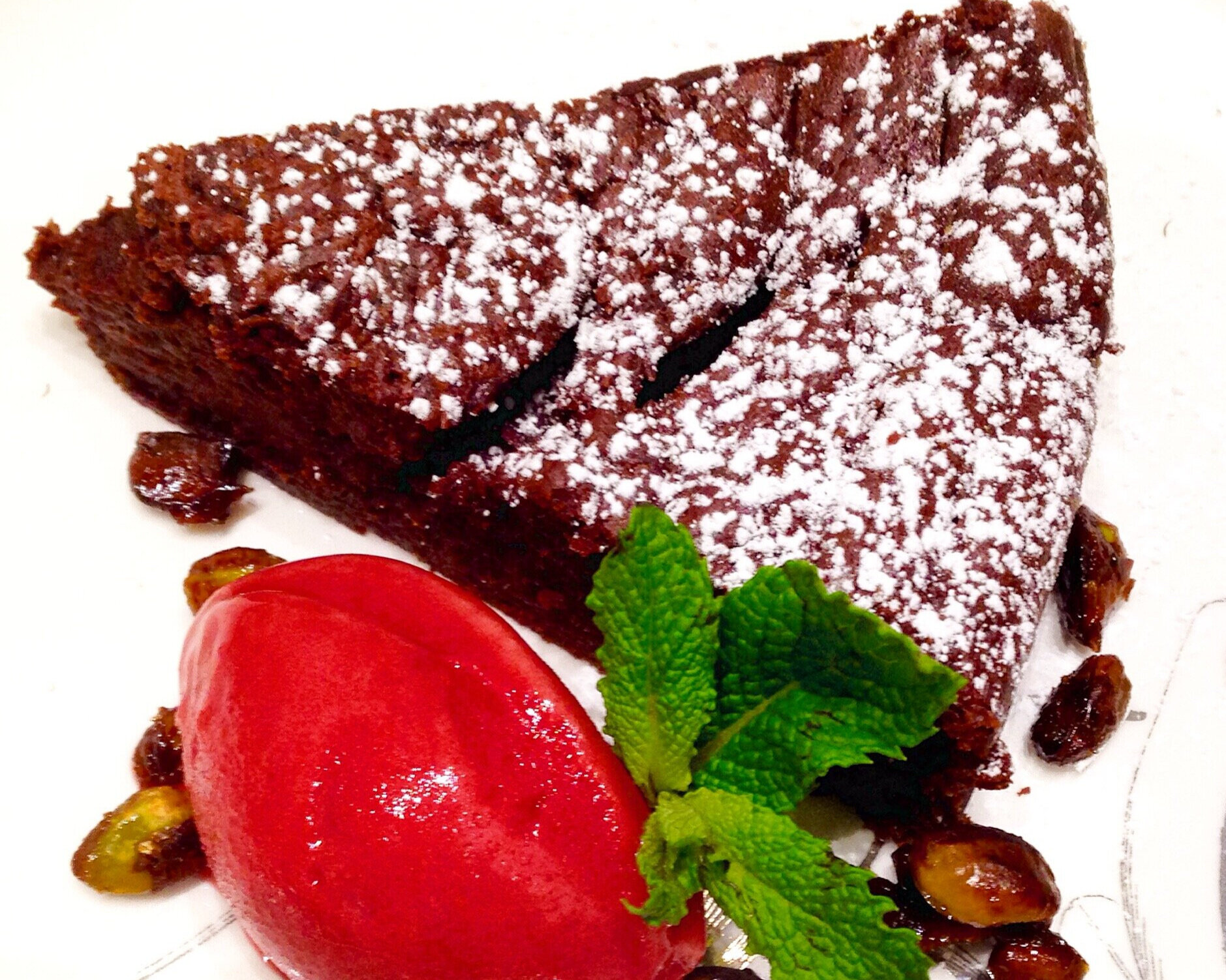 Flourless chocolate cake, raspberry sorbetto, candied pistachios