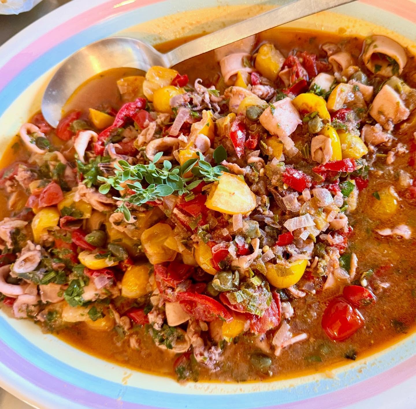 Calamari in guazzetto with datterini (tomatoes), tuna-stuffed pickled peppers, capers, white wine, and fresh herbs. Cooked slow and low. #bluaubergine #fabulousfood #bluauberginetravels #privatechef #catering #cucinaitaliana🇮🇹 #calamaribuoni