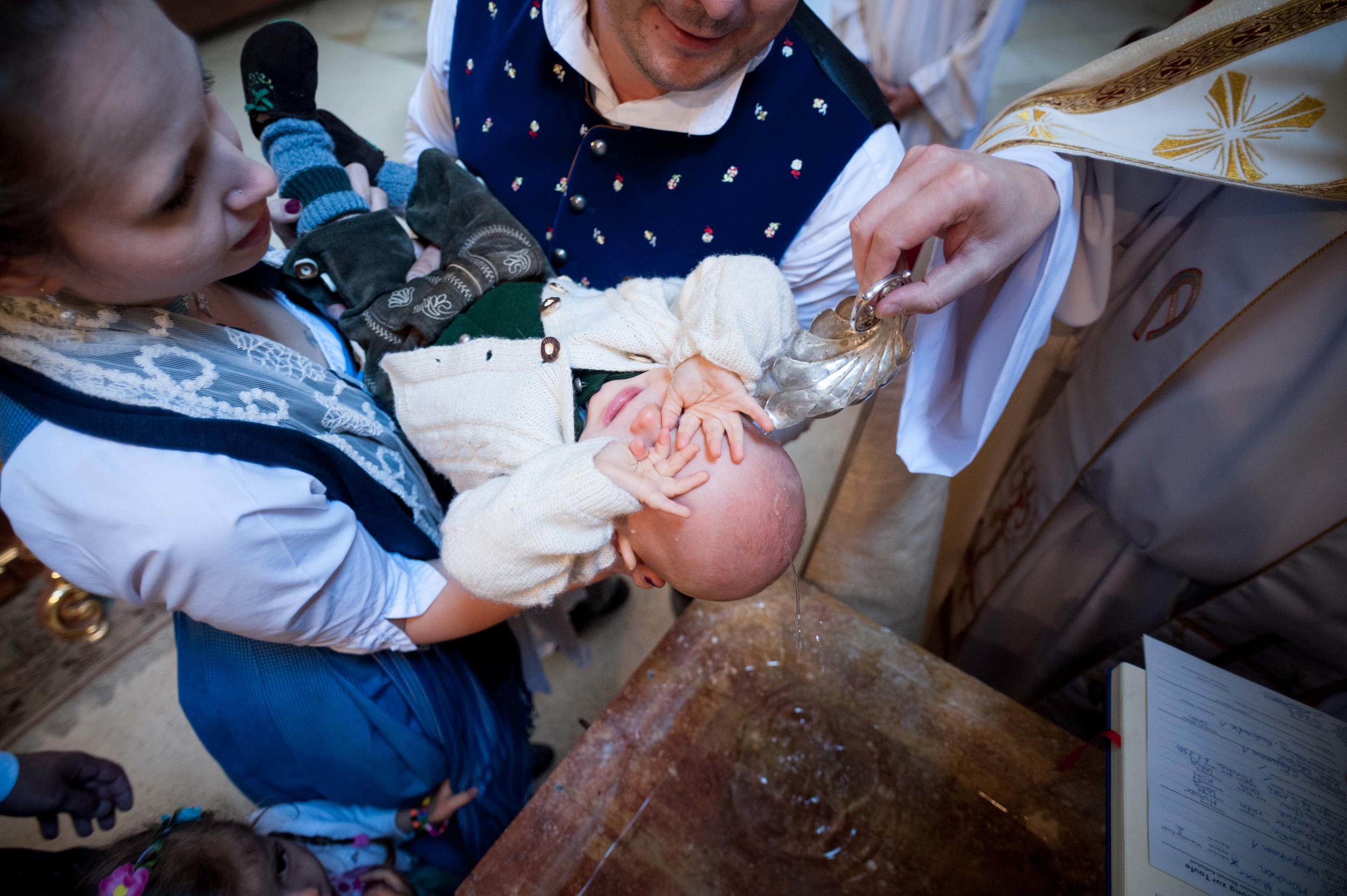S. Huber is hold by his parents while the priest is christening him with holy water at Steingau, Germany, 30 Mai 2015.
