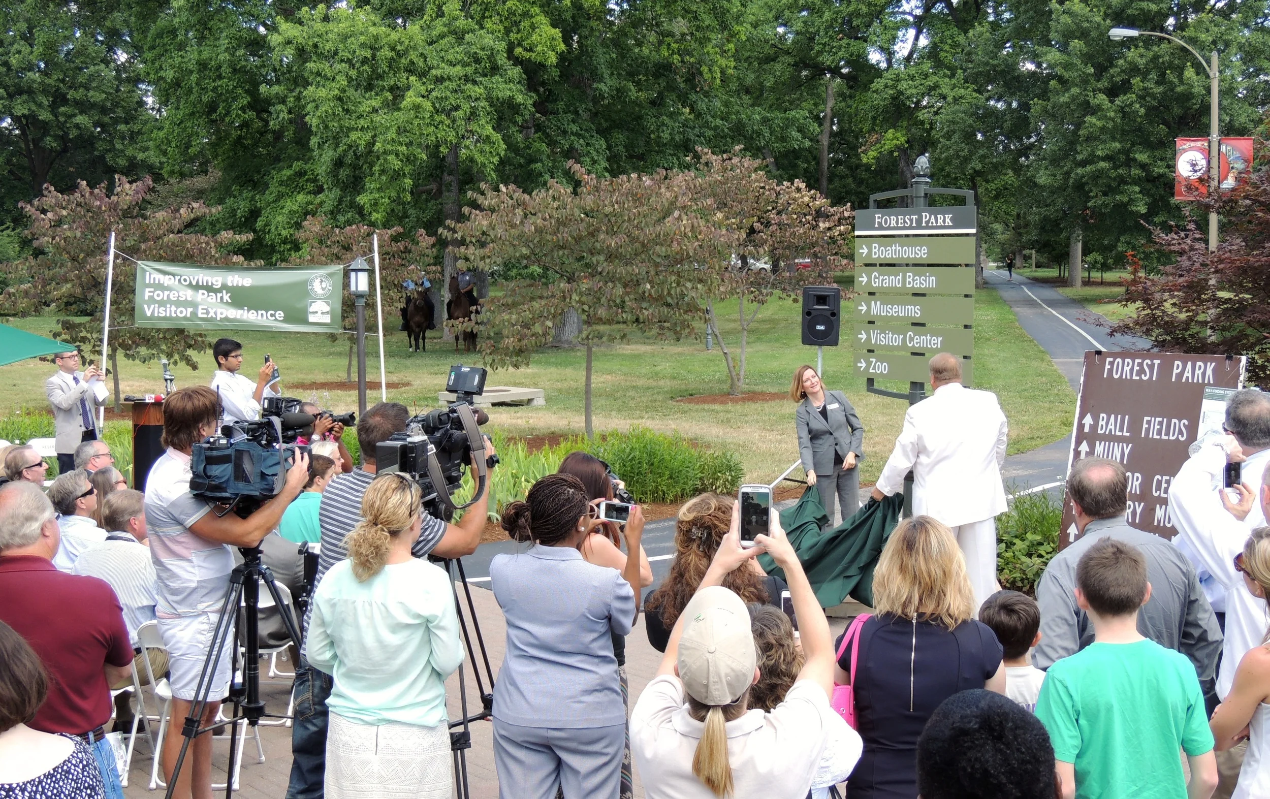 Lesley Hoffarth and Gary Bess unveil the first new Forest Park sign. ( View more photos. )