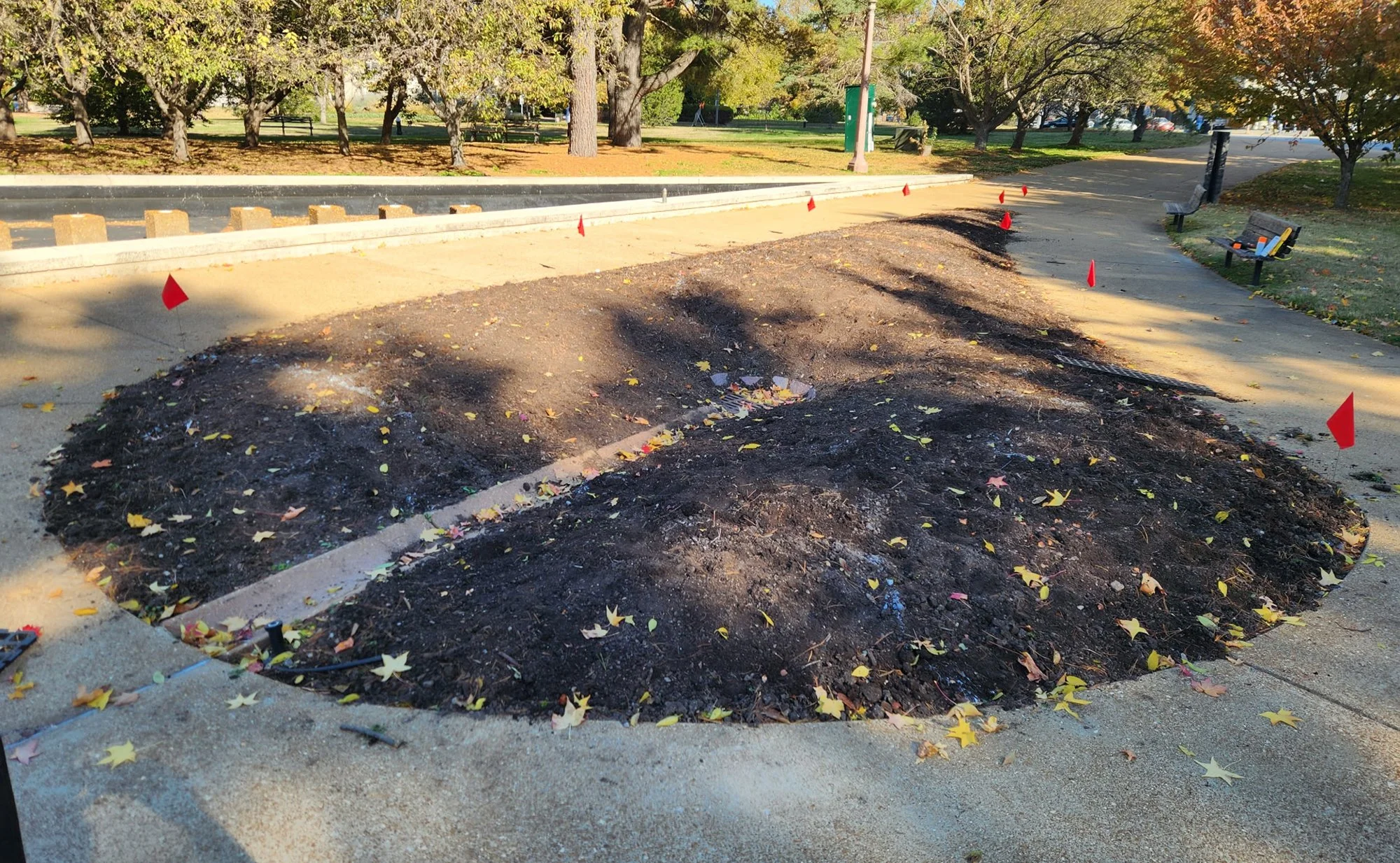 Photo of bare soil in a flowerbed near the Jewish Tercentenary Monument