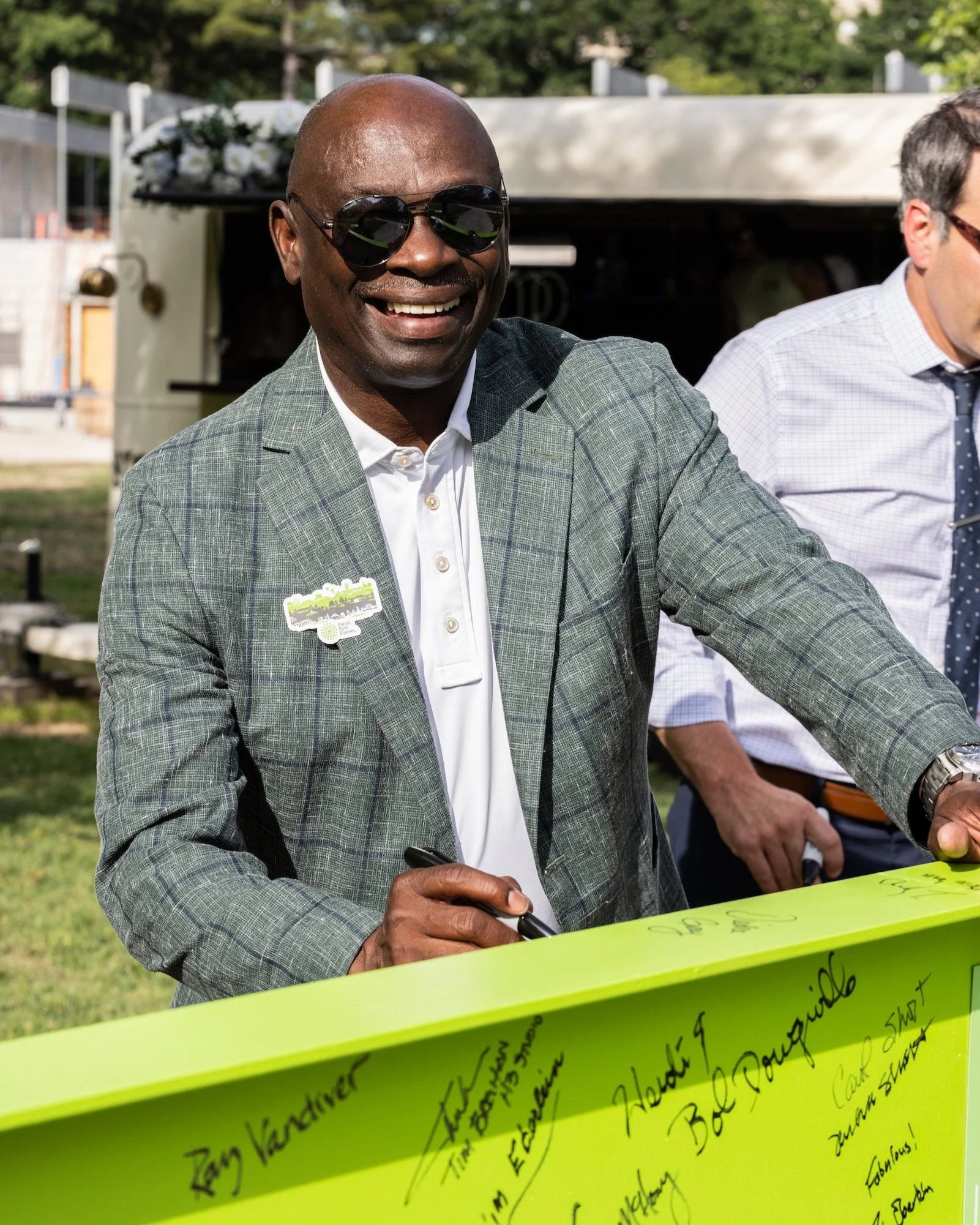Larry Thomas smiling at the camera while signing a beam to be installed in the renovated Steinberg Rink facility at the Glade in Forest Park