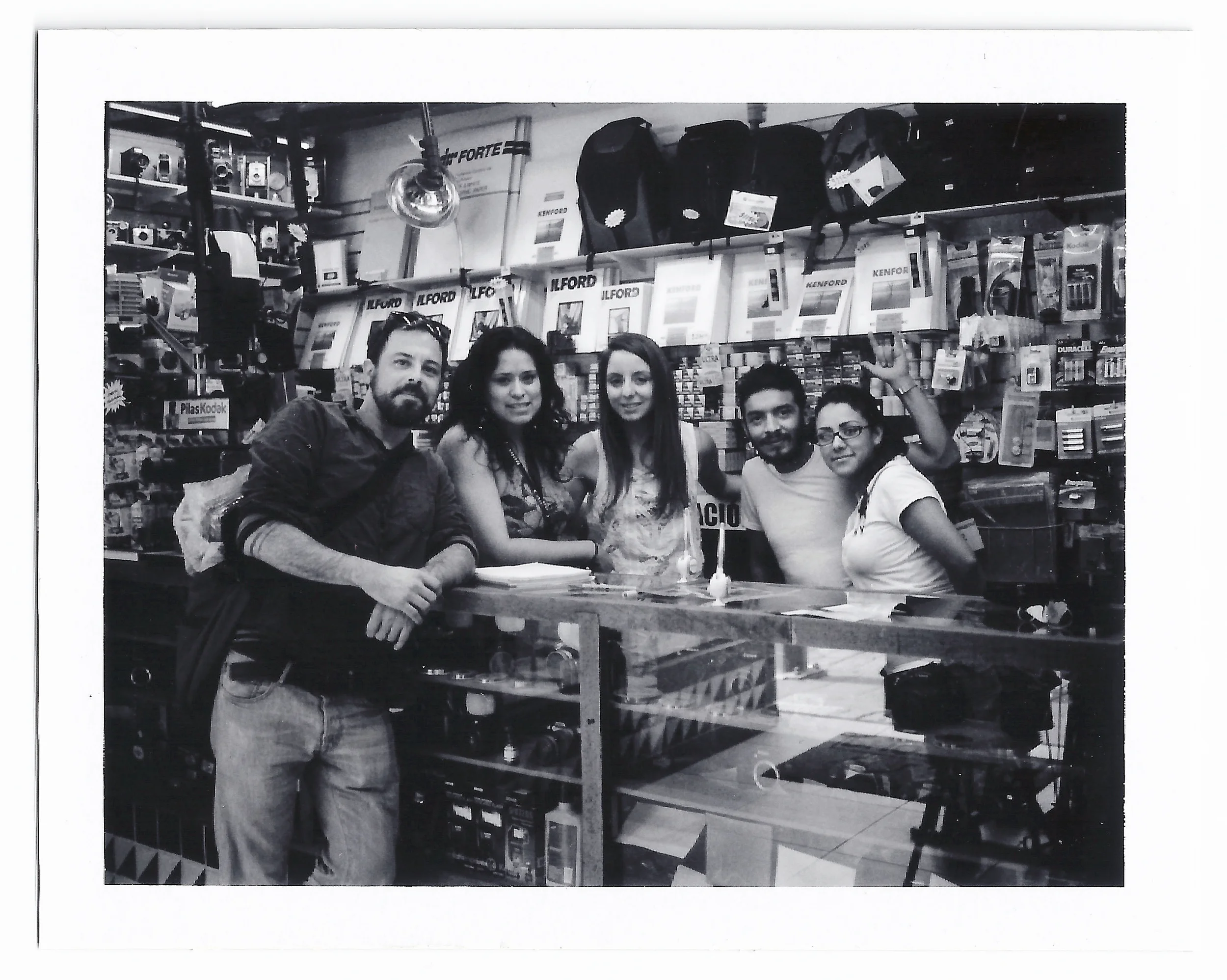 The salespeople at the shop, Eduardo, Johana, and Karla, are quite reserved at the beginning, but as time goes by and we ask an endless amount of questions about all sorts of photographic equipment, they warm up to us. They wonder about how we met and I tell them we only met a couple of hours ago. We take pictures inside the store. I take a group shot of all Julien with them.