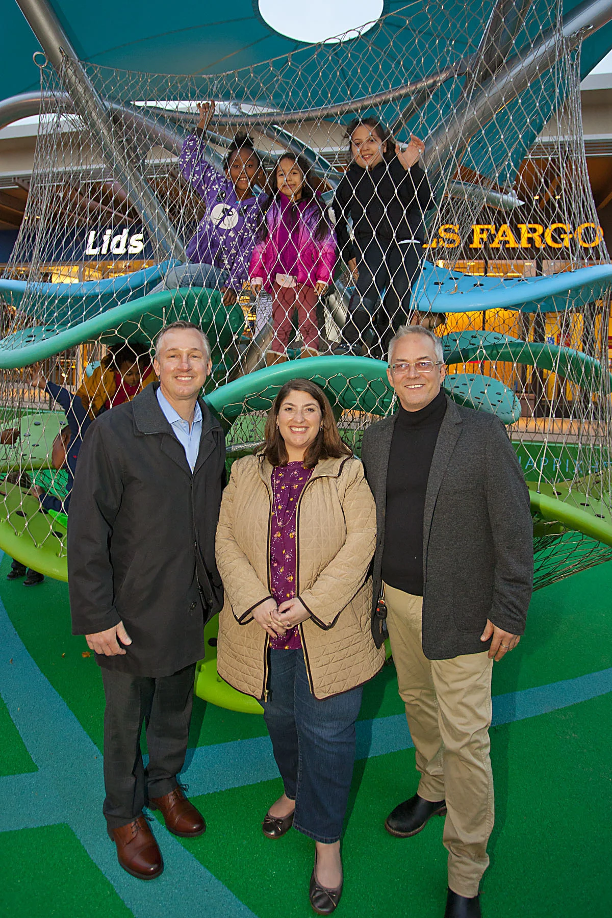 Picture here: children at play during the grand opening, Carl Calabro and Liz Pollack from Cross County Shopping Center, and Heurista’s Ed Manner