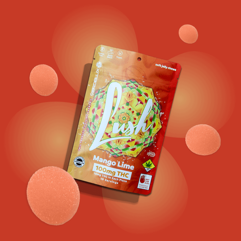 Package of Lush Mango Lime soft jelly chews with 100mg THC, featuring colorful, geometric design and cannabis leaf icon, surrounded by peach-colored jelly candies on a red background.