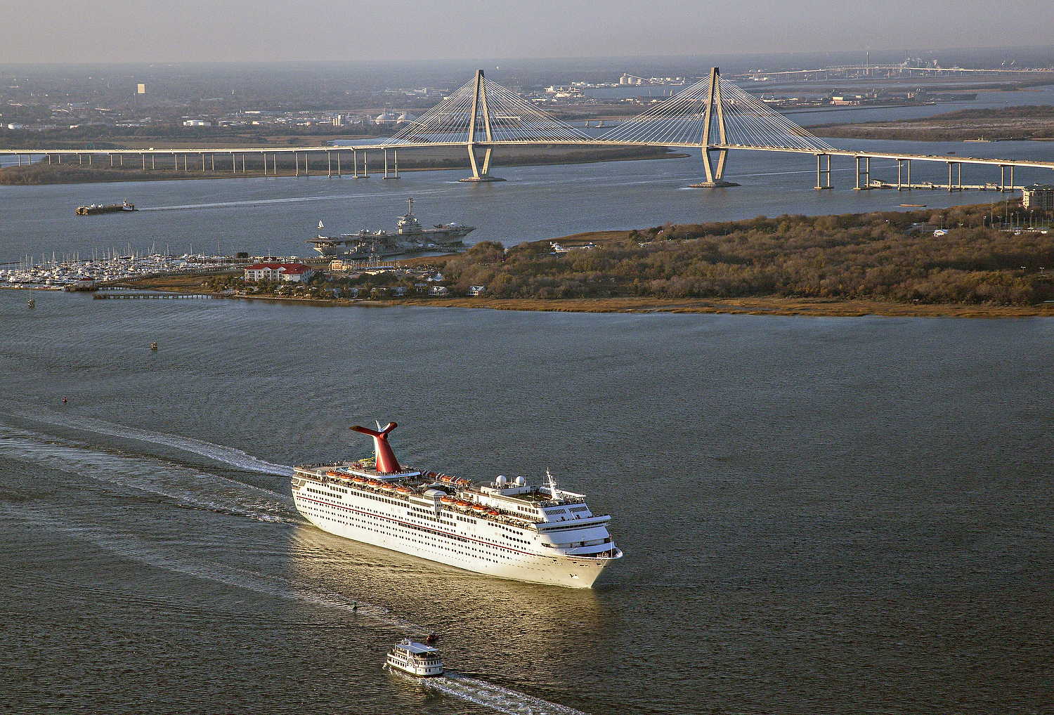  Aerial showing Carnival Cruise Lines ship departing Charleston Harbor with the Ravenel Bridge in the background in Charleston, SC. 
