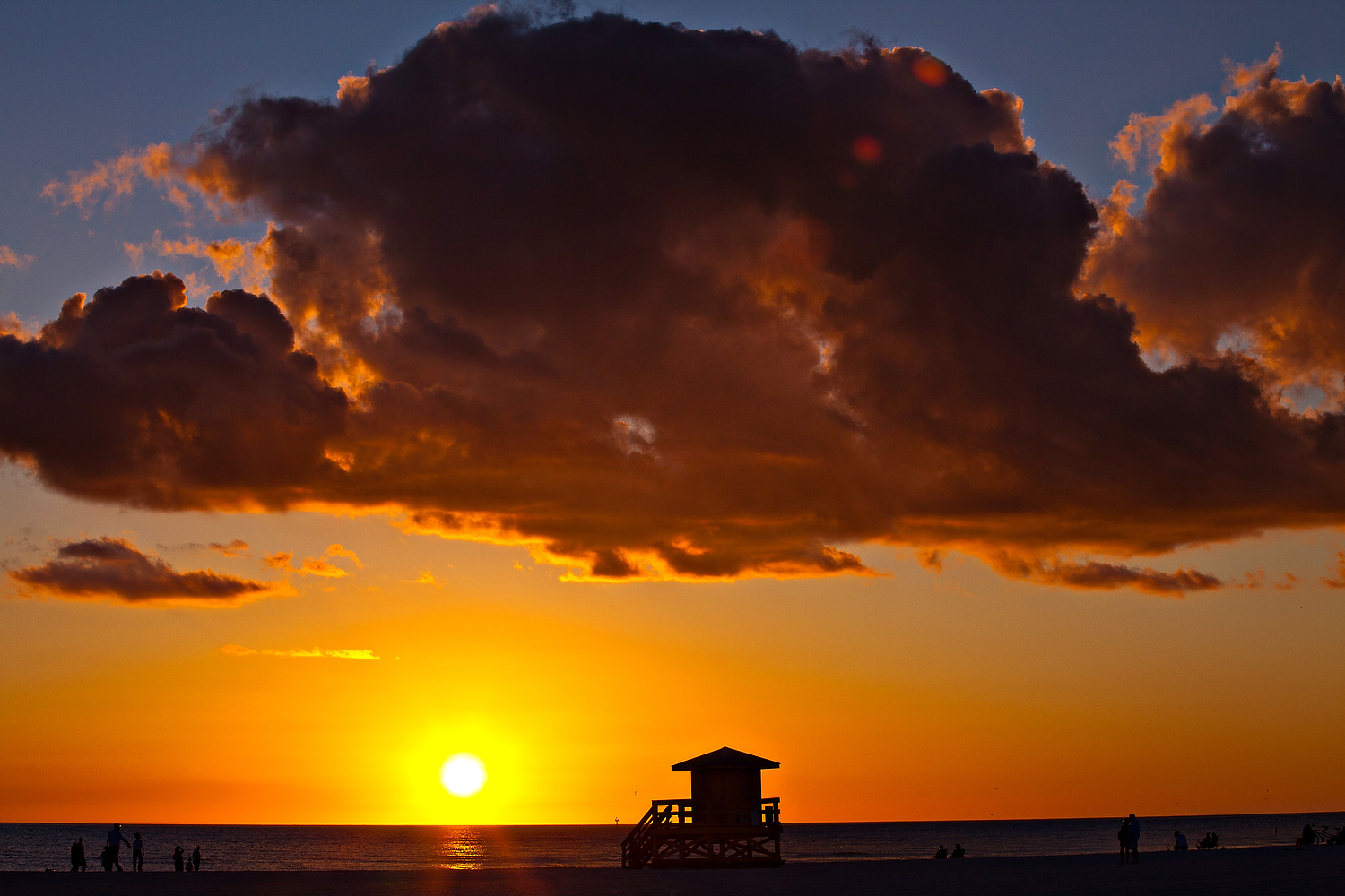  Sunset silhouettes lifeguard station on famed white powder sand Siesta Key beach, Sarasota Florida 