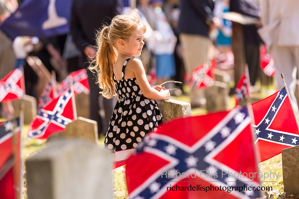 A young girl stands among Confederate flags decorating tombs of soldiers killed in the American Civil War during Confederate Memorial Day events at Magnolia Cemetery April 10, 2014 in Charleston, SC. Confederate Memorial Day honors the approximately 258,000 Confederate soldiers that died in the American Civil War. 
